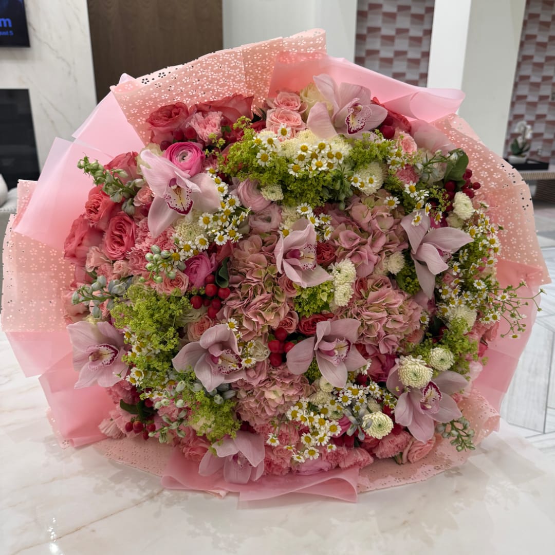 Large pink bouquet with orchids, roses, and small white daisies
