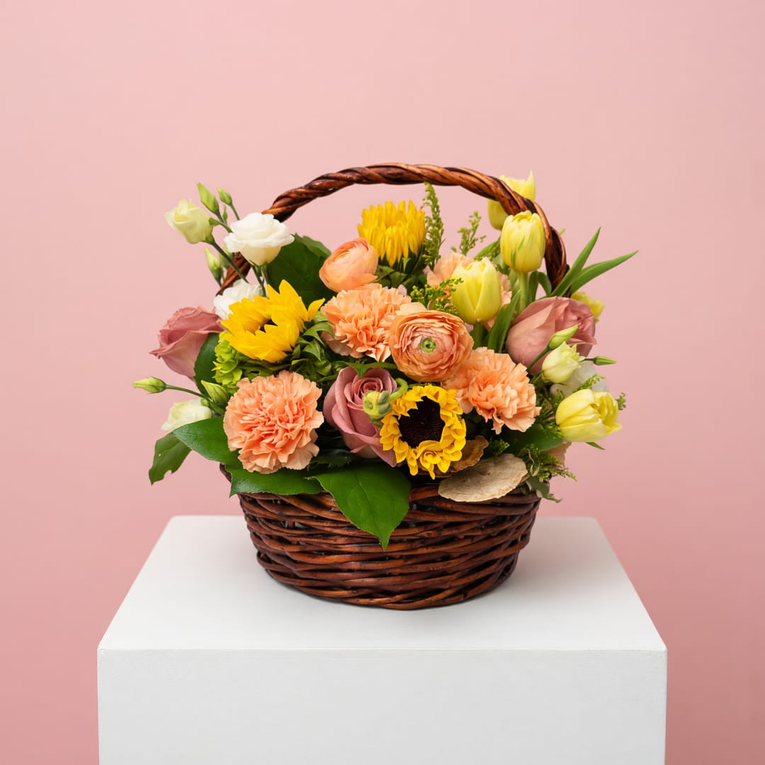 Mixed flower basket with sunflowers, roses, carnations, and tulips