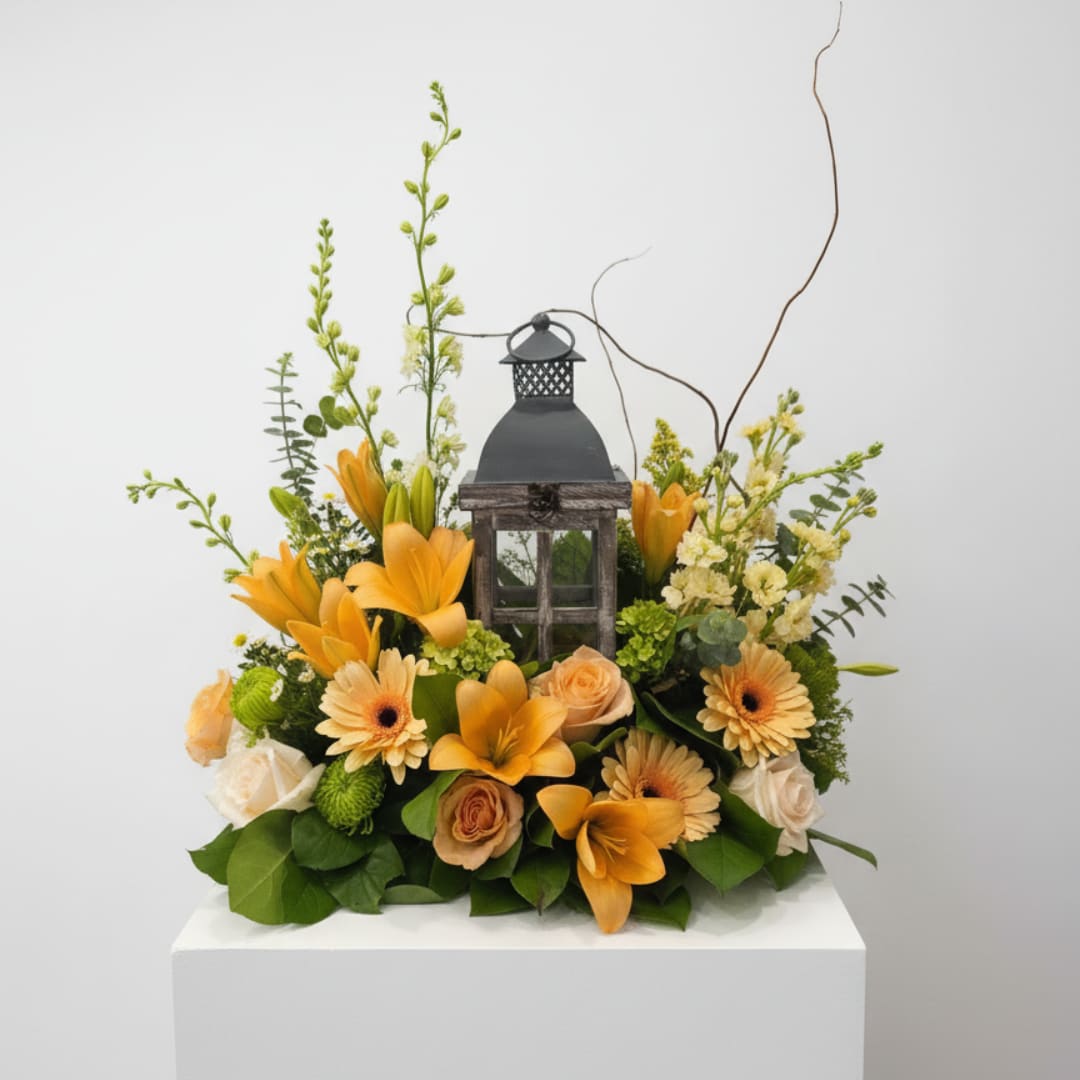 Orange floral arrangement with a decorative lantern centerpiece