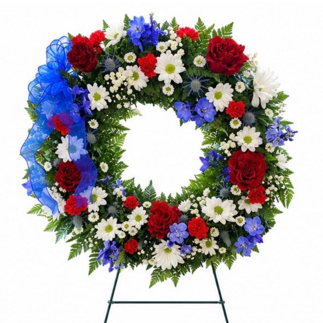 Circular floral wreath with red, white, and blue flowers on a stand