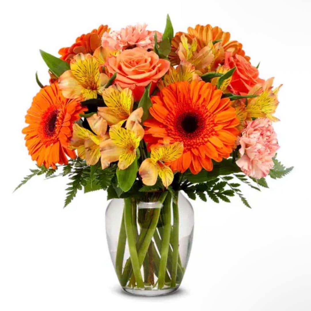 Bouquet of orange and pink flowers in a clear glass vase