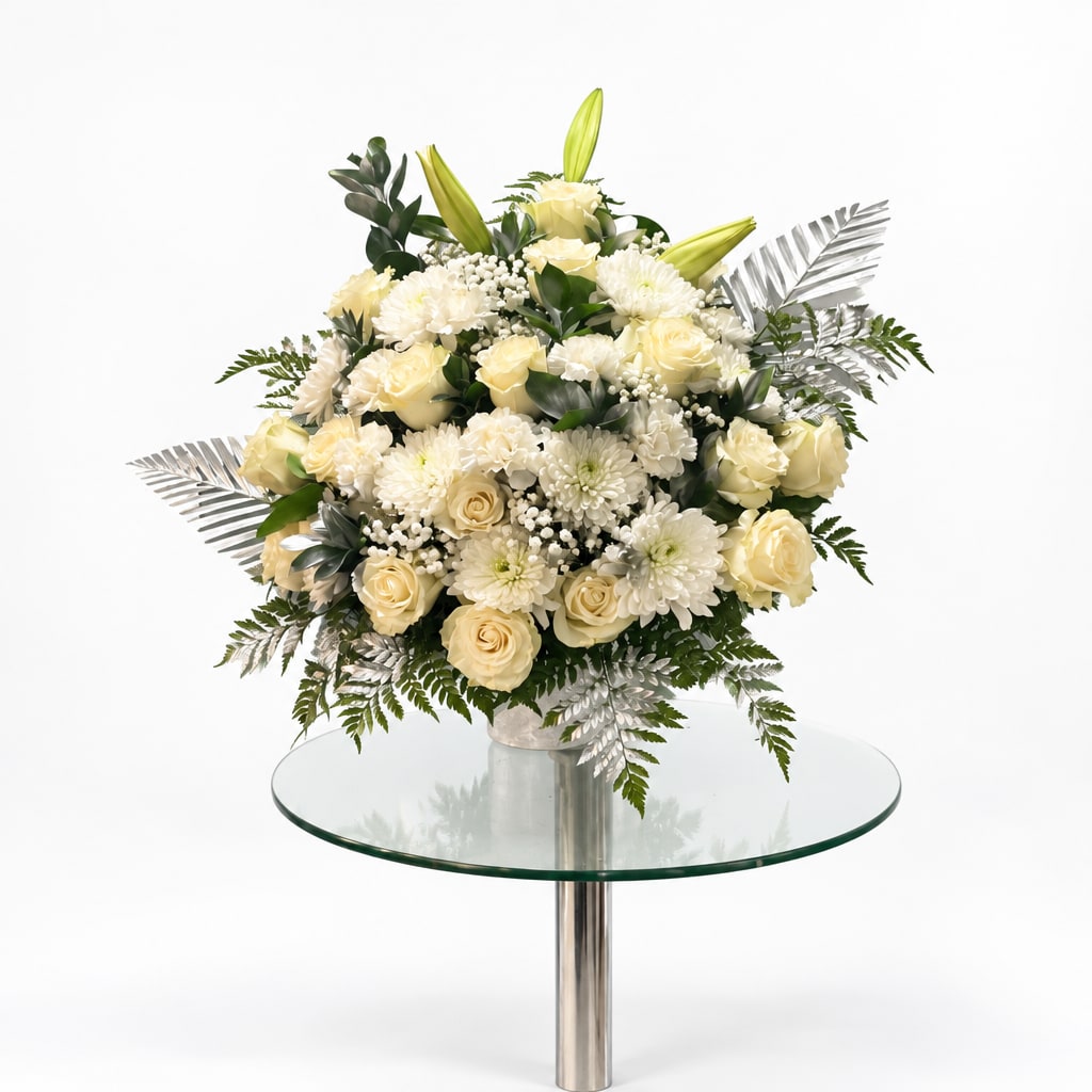 Cream roses and white mums arranged in a low vase centerpiece