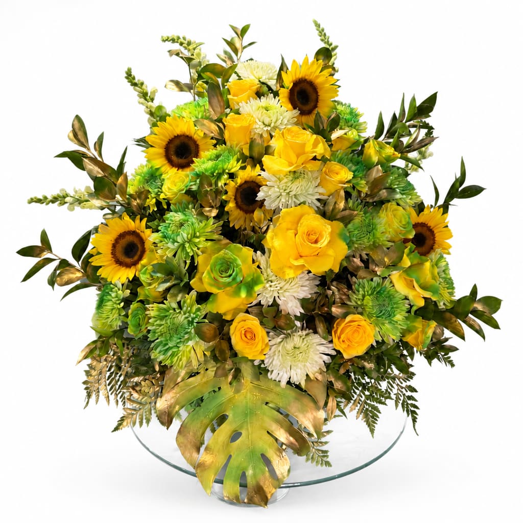 Yellow roses and sunflowers in a glass bowl vase