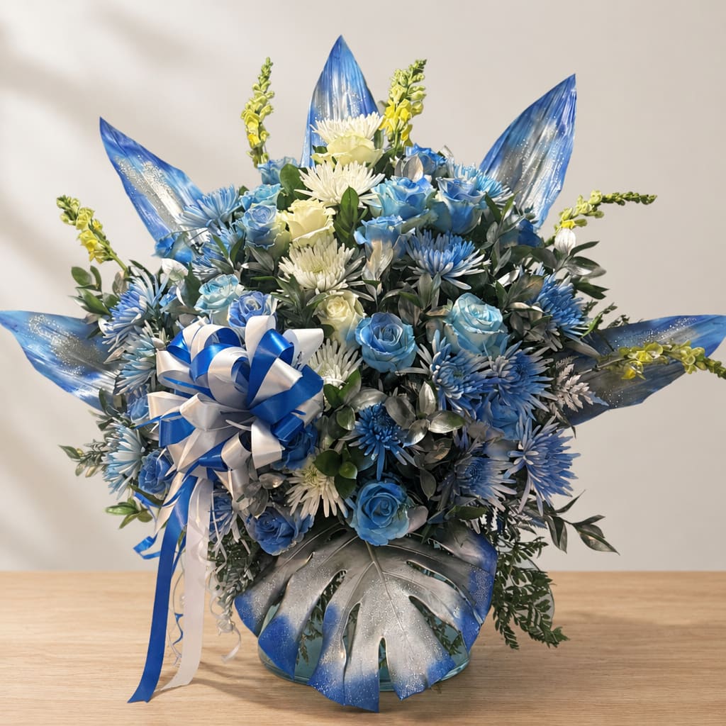 Blue and white bouquet with roses, chrysanthemums, and a ribbon in a glass vase
