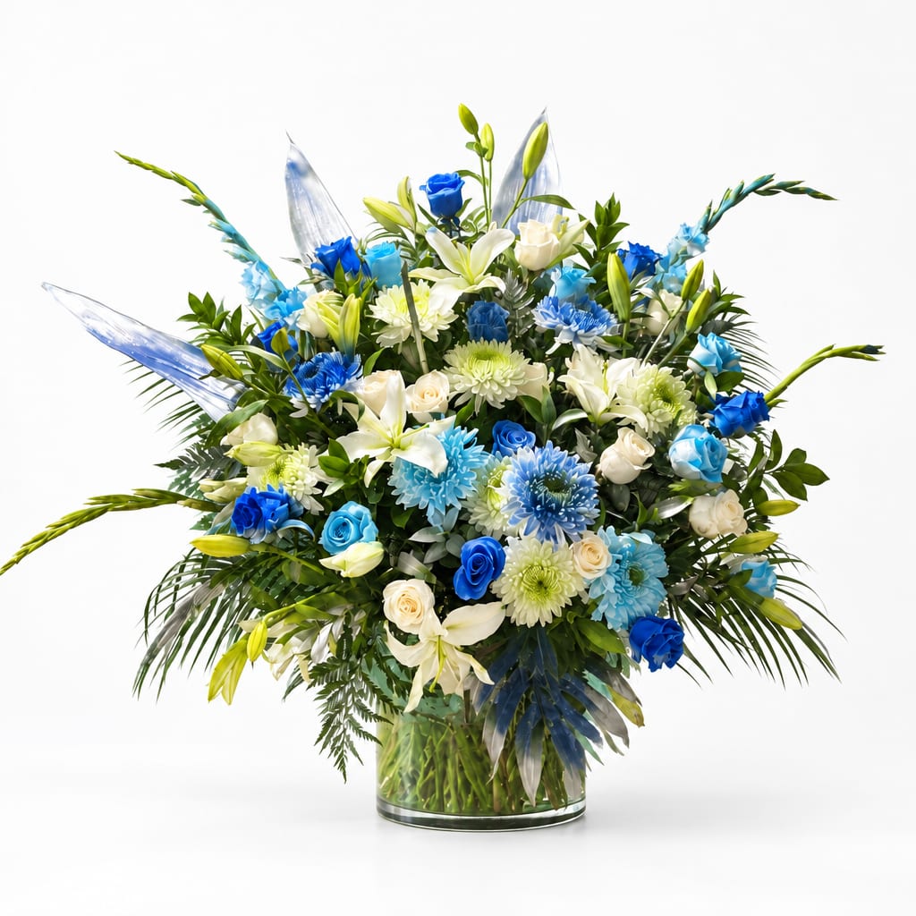 Blue and white mixed flower arrangement in a clear glass vase