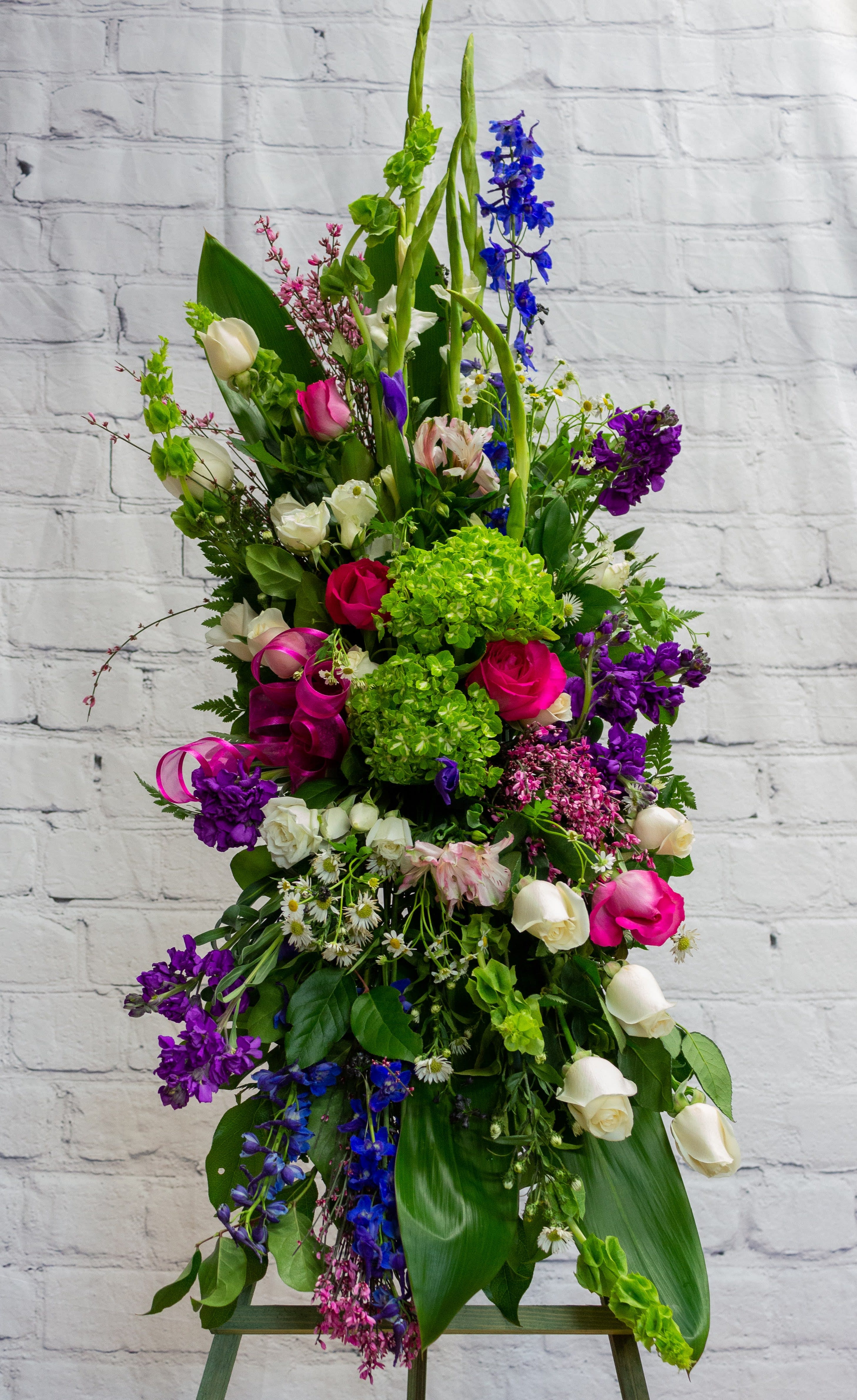 Tall mixed floral arrangement with pink, white, purple, and blue blooms