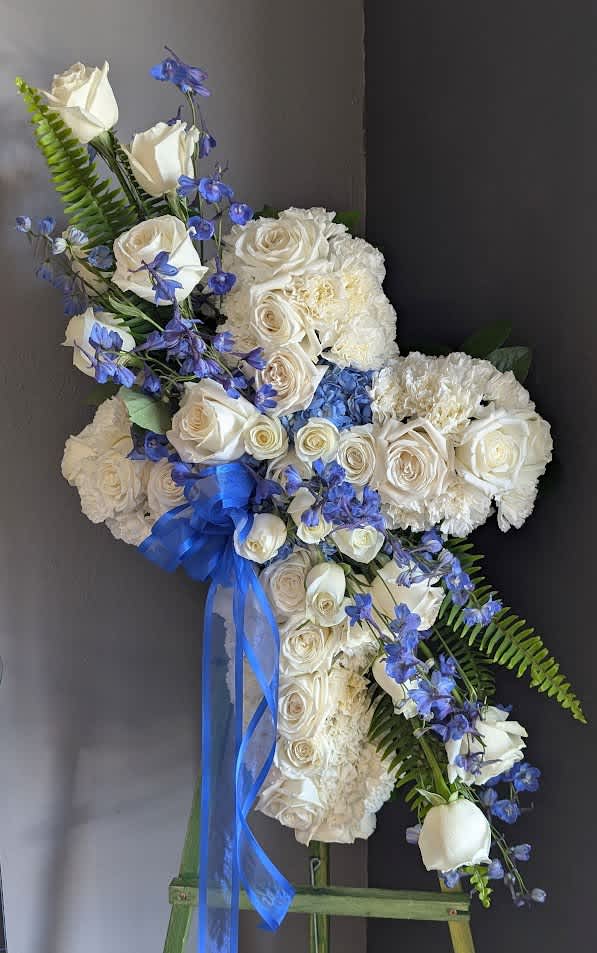 White rose and hydrangea floral spray with blue ribbon and blue flowers
