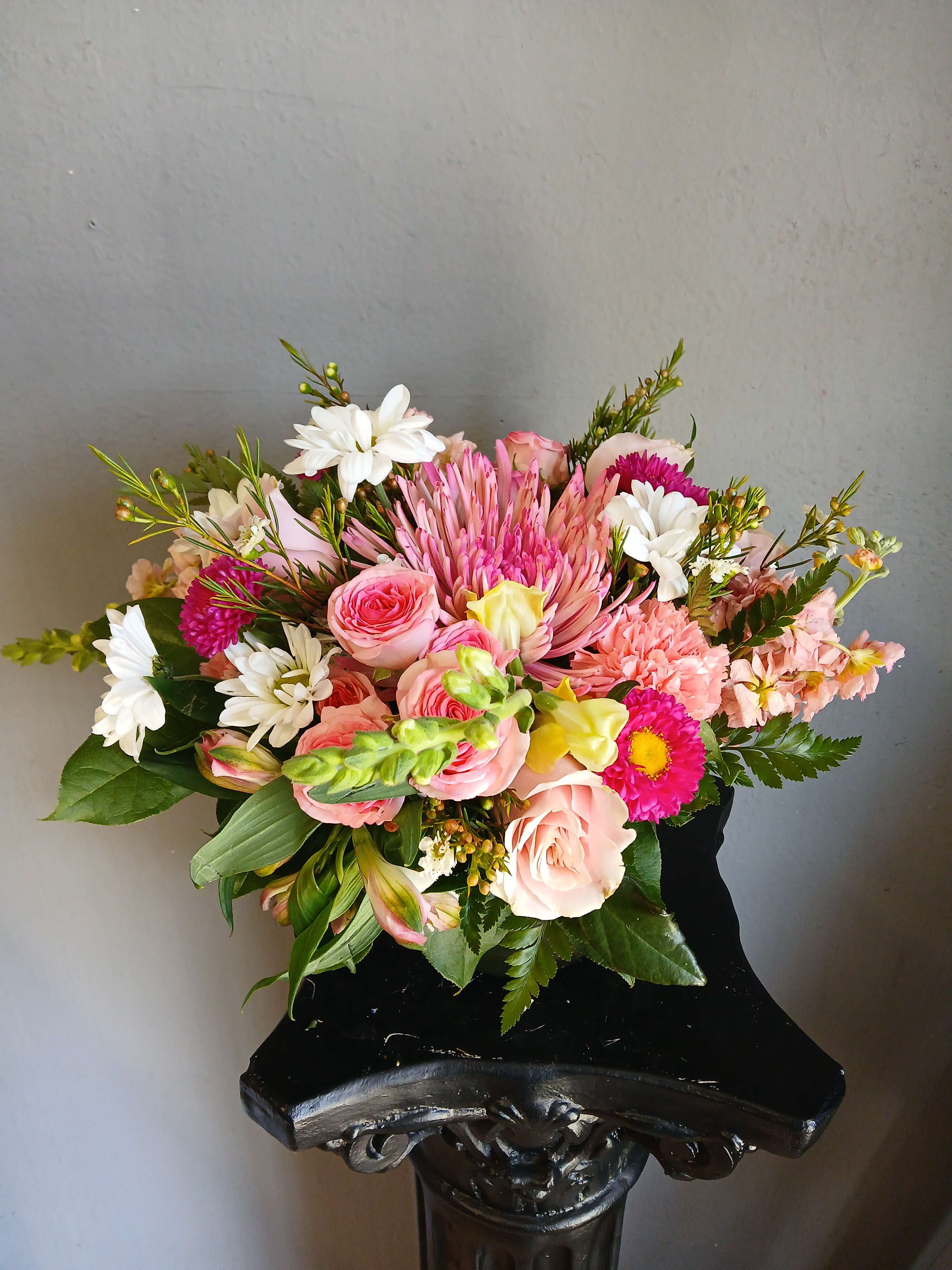 Pink and white mixed bouquet in a black vase
