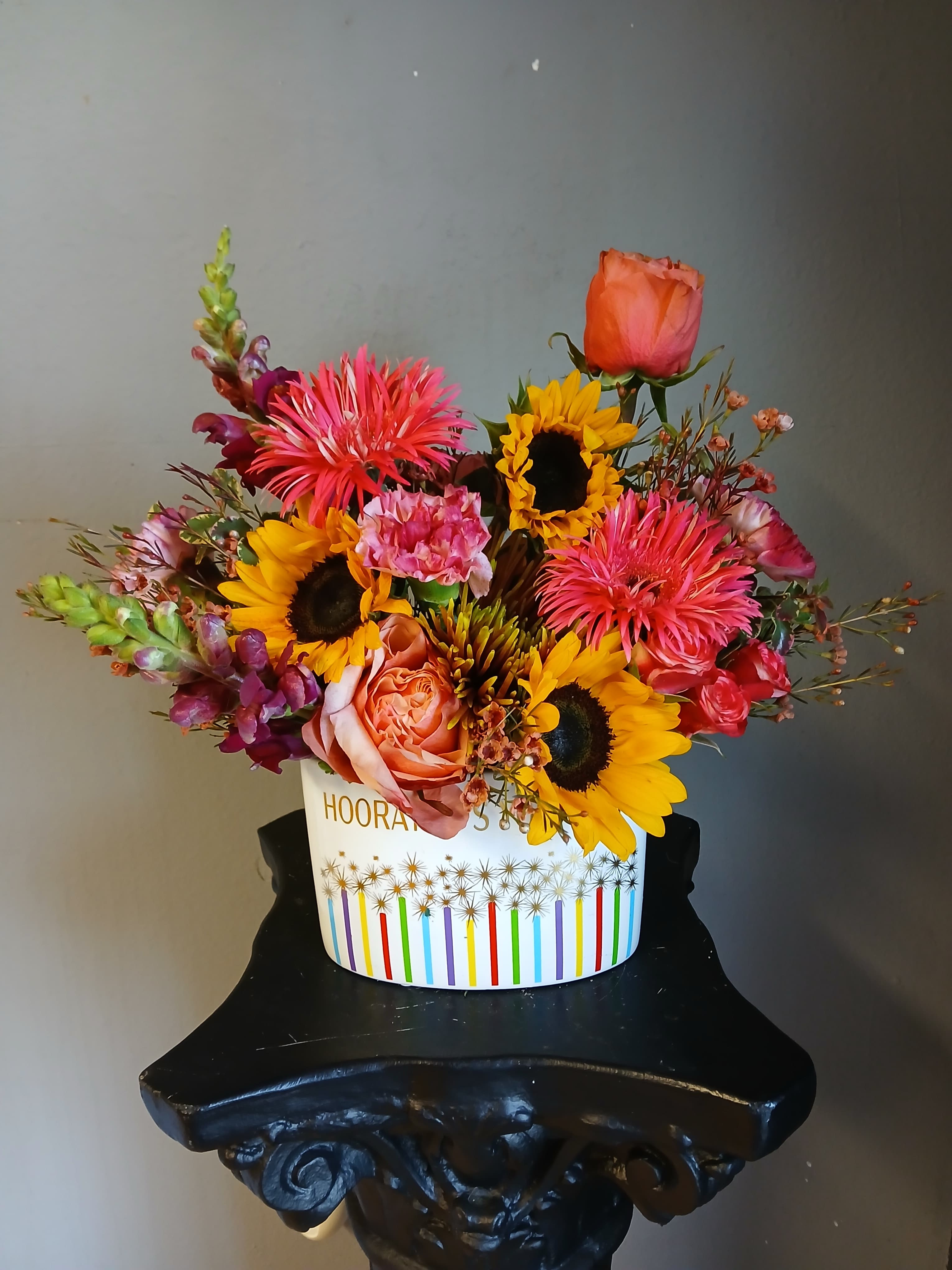 Mixed bouquet with sunflowers, roses, and bright pink blooms in a white box