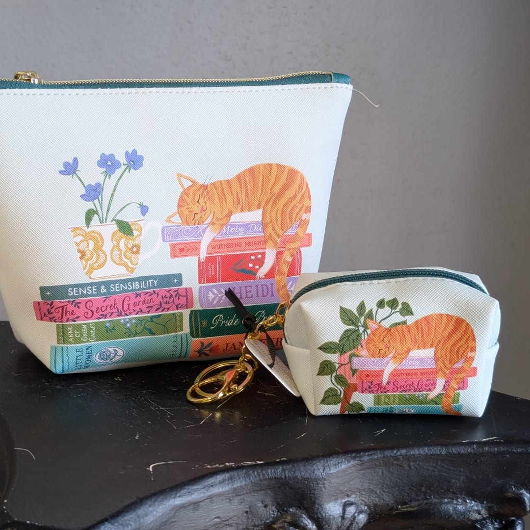 Two floral-print zip pouches with an orange cat and books