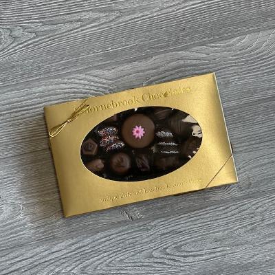 Box of assorted chocolates with a gold wrapper and window cutout