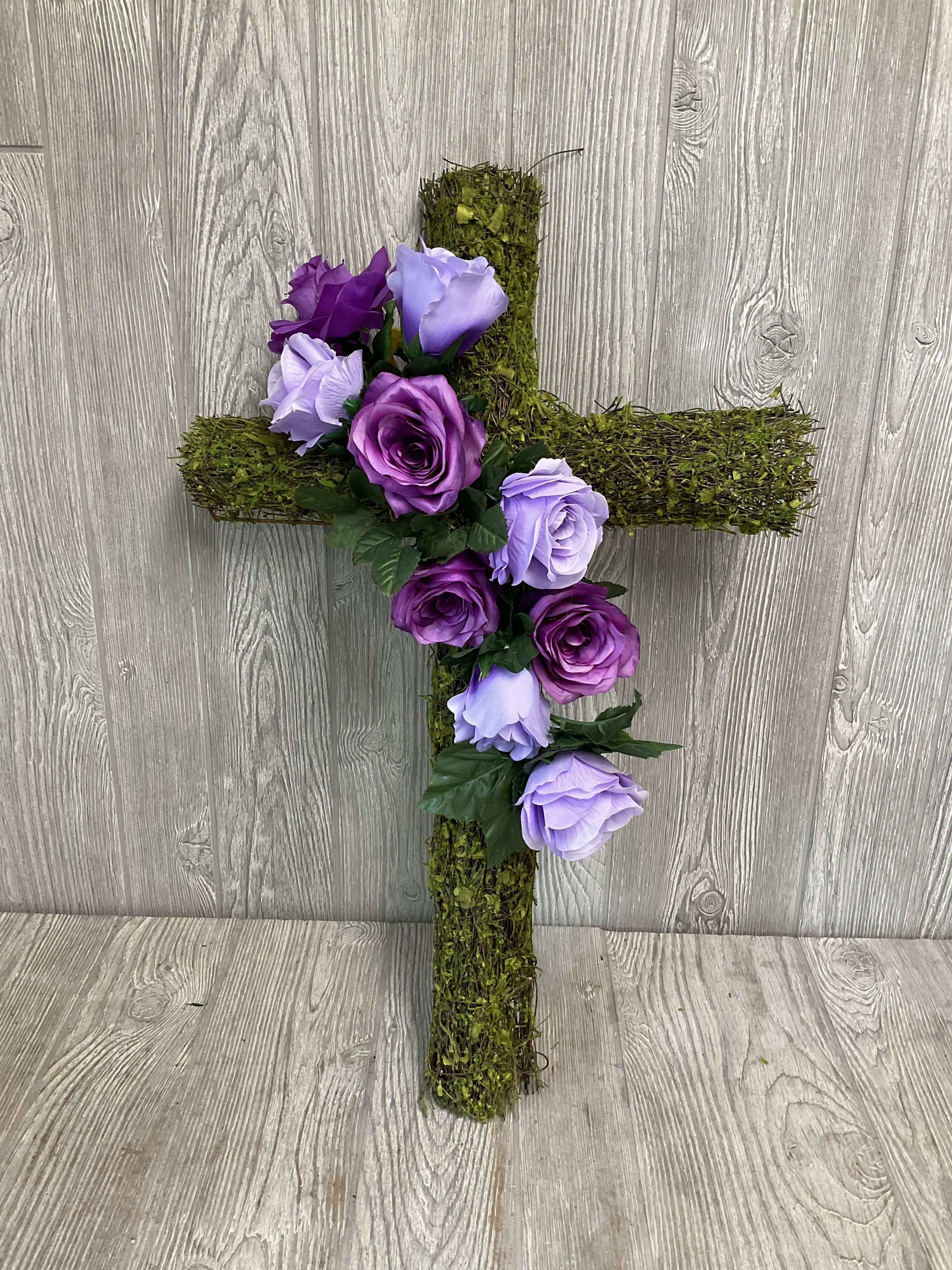 Moss-covered cross with purple and lavender roses
