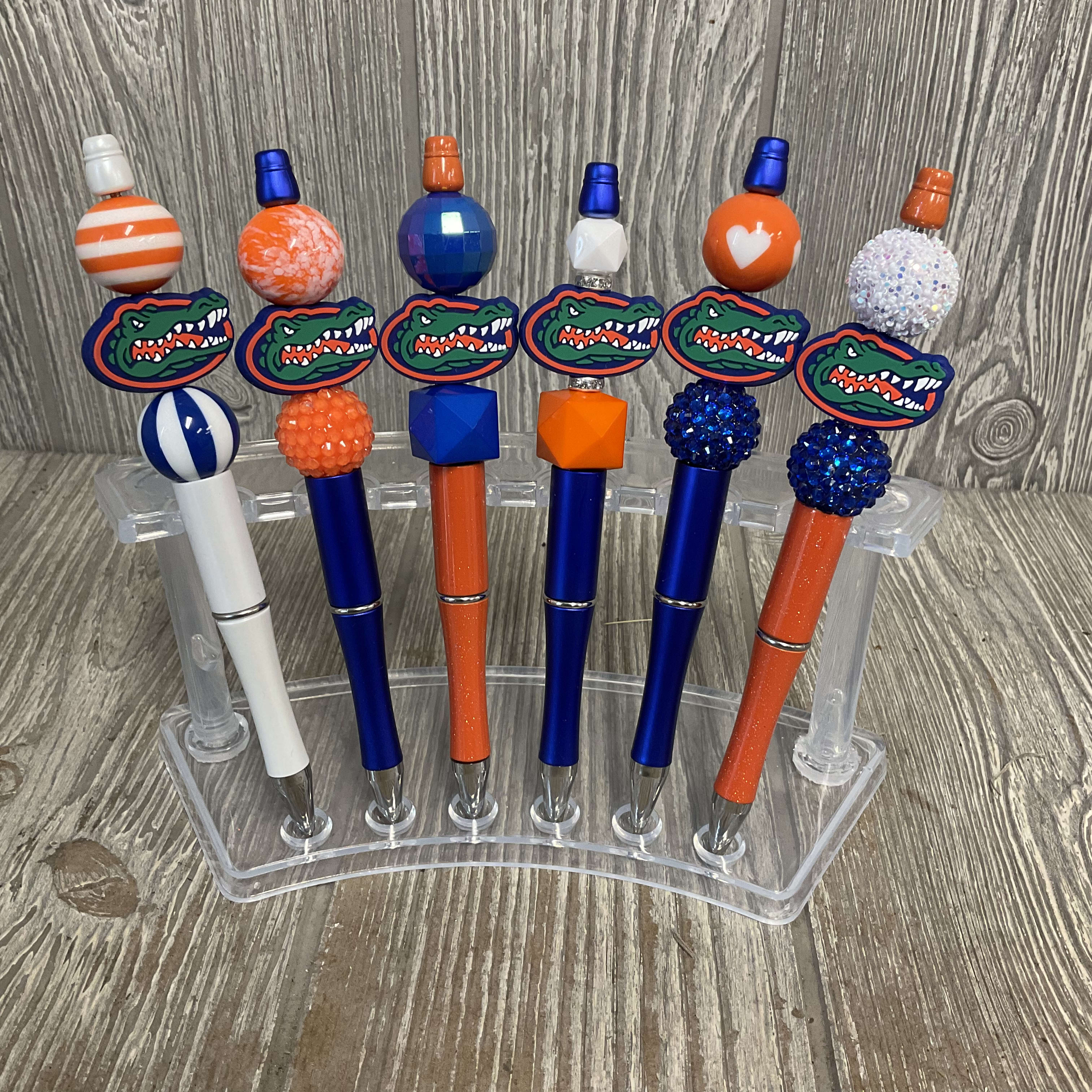 Six decorated pens with Florida Gators logos in a clear holder