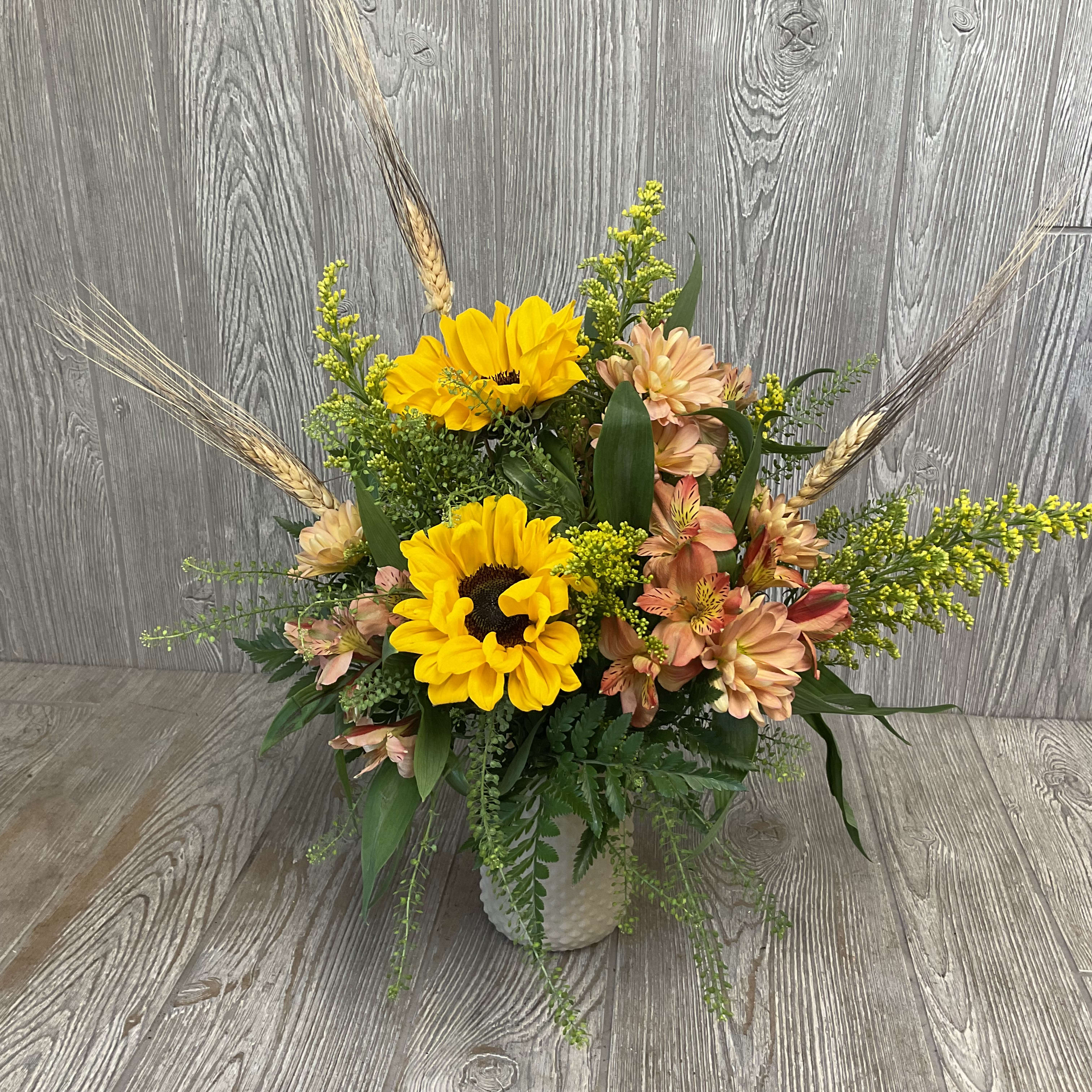 Sunflower and peach flower arrangement in a white vase
