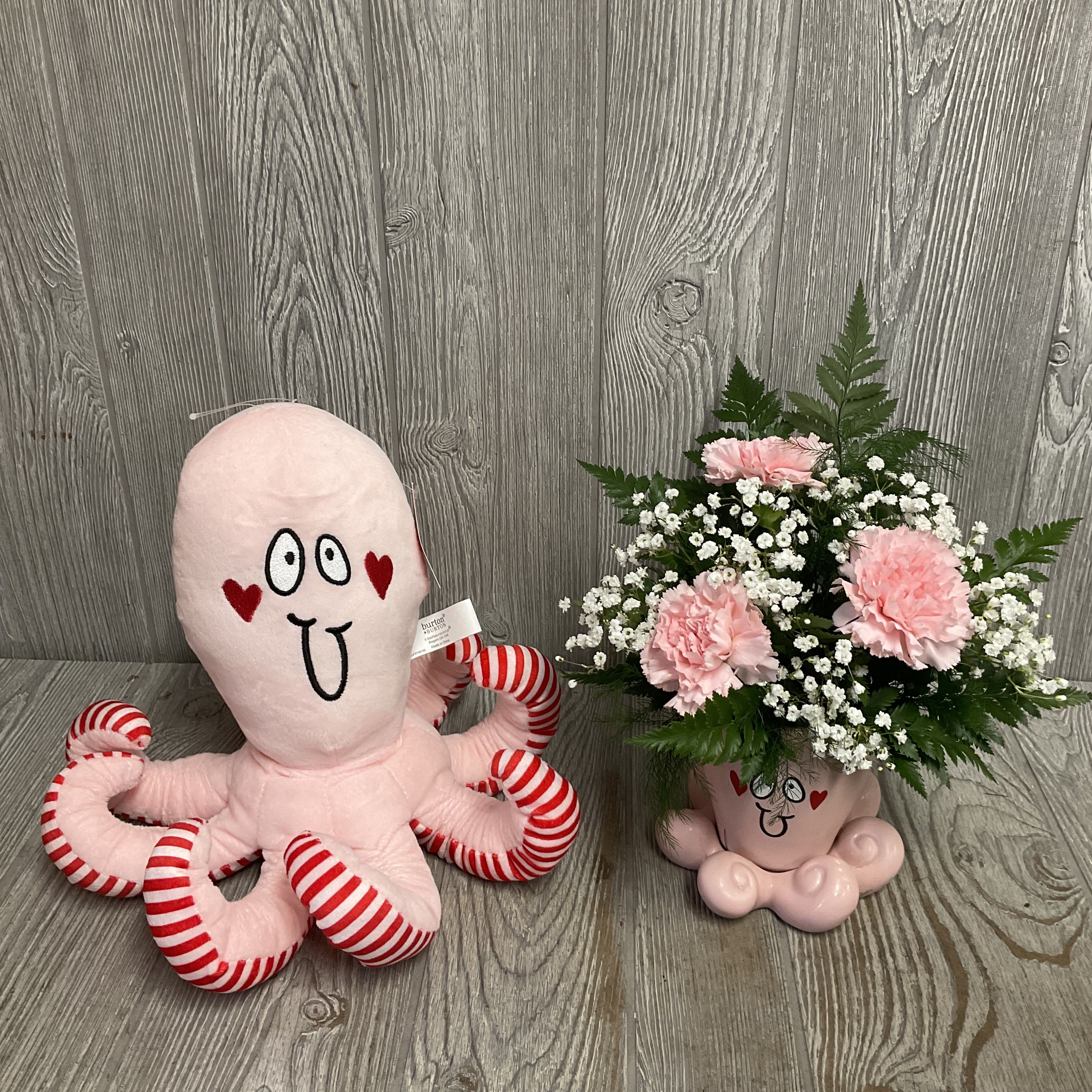 Pink plush octopus beside a pink carnation bouquet in a novelty mug