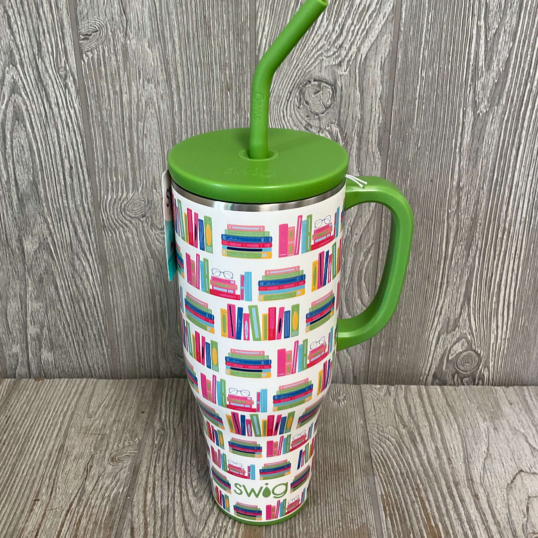 Green handled travel mug with a colorful bookshelf pattern and straw lid