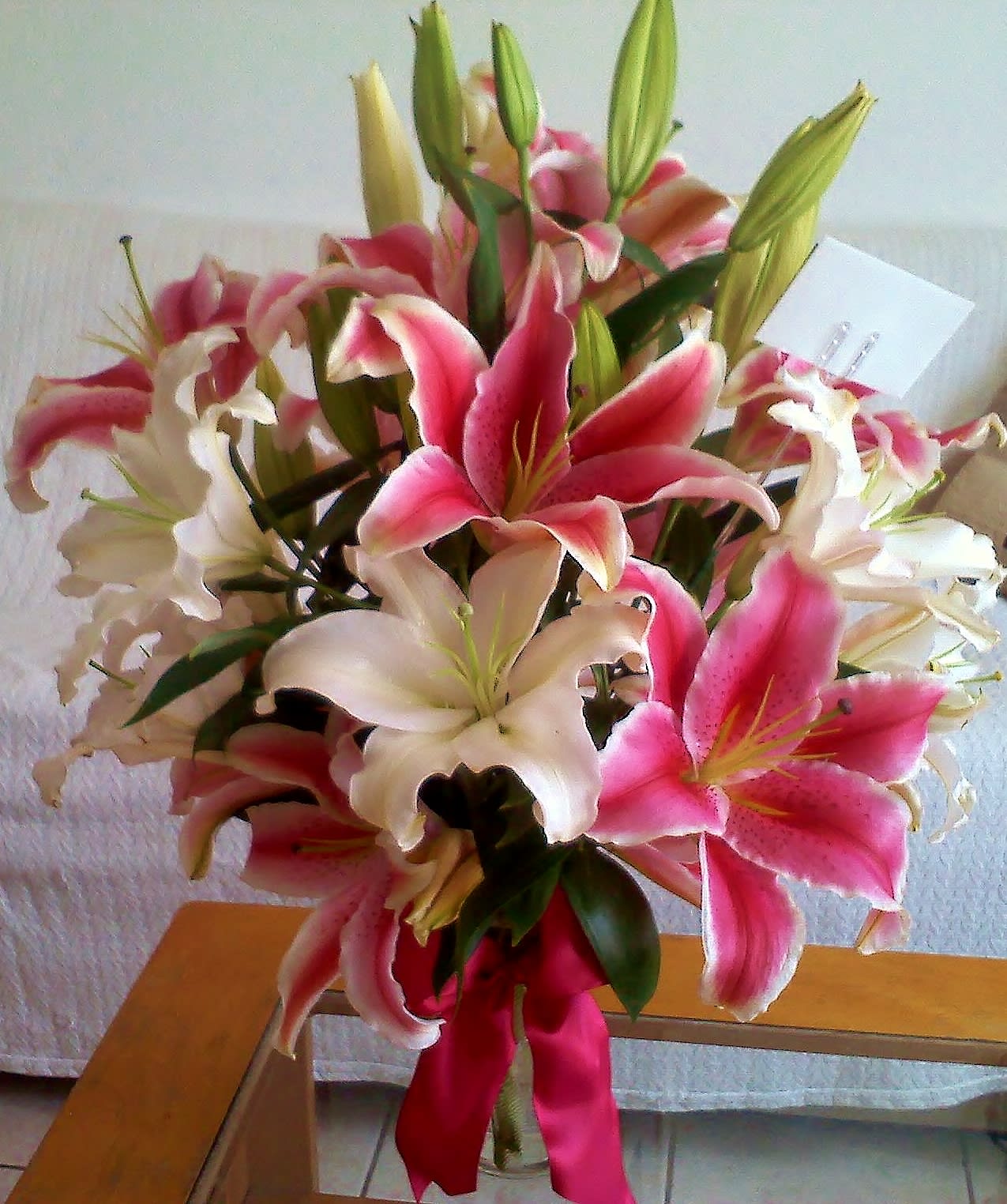 Bouquet of pink and white lilies with a pink ribbon