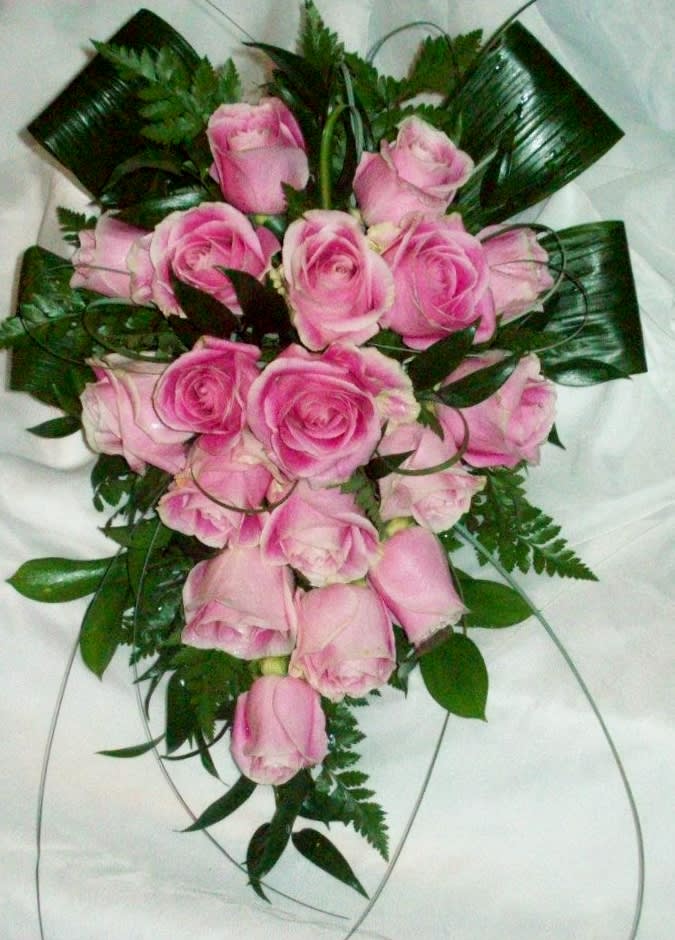 Pink rose bouquet with dark green foliage on a white background