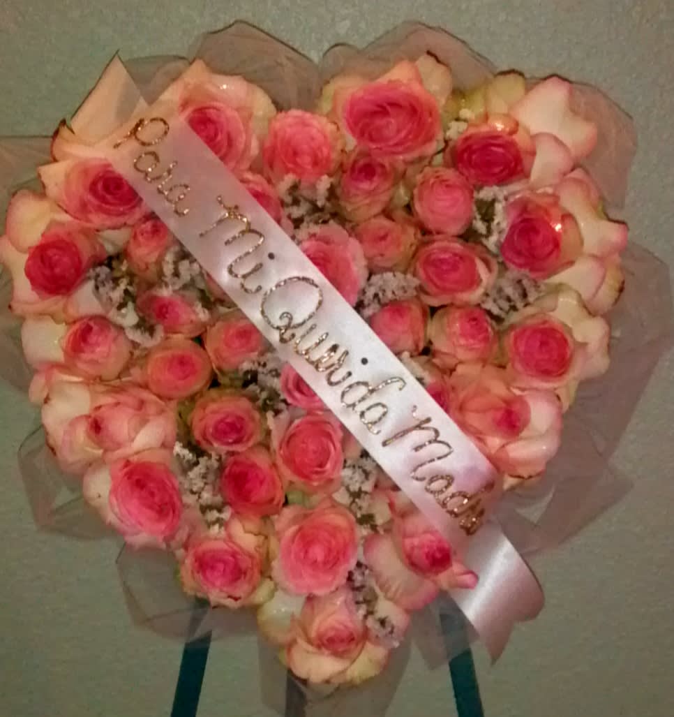 Heart-shaped bouquet of pink roses with a satin ribbon