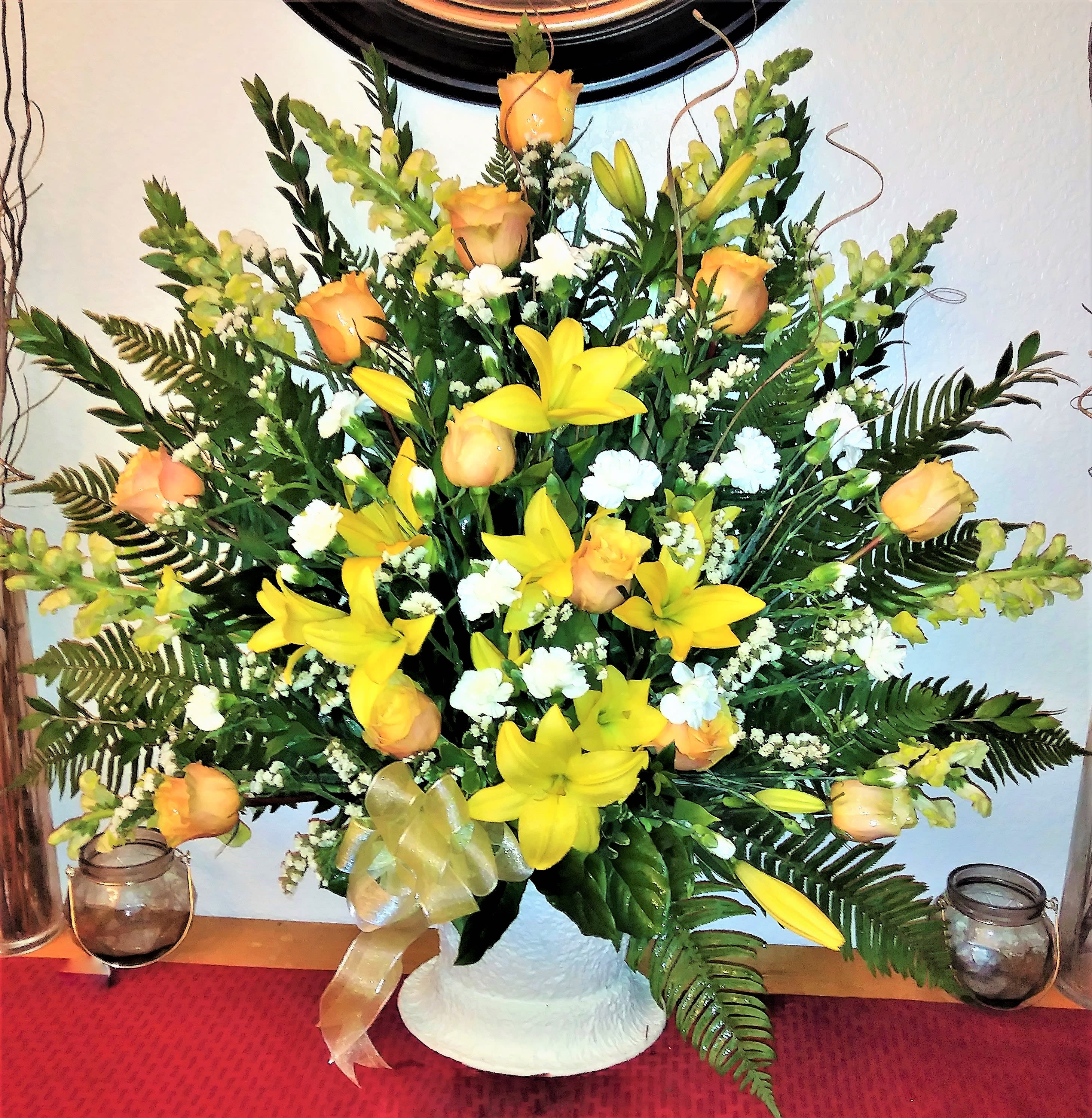 Yellow lilies and peach roses in a white vase