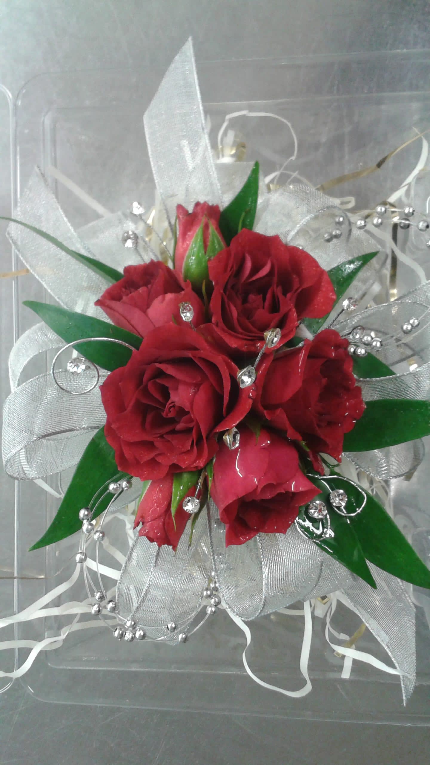 Small bouquet of red roses with silver ribbon and bead accents