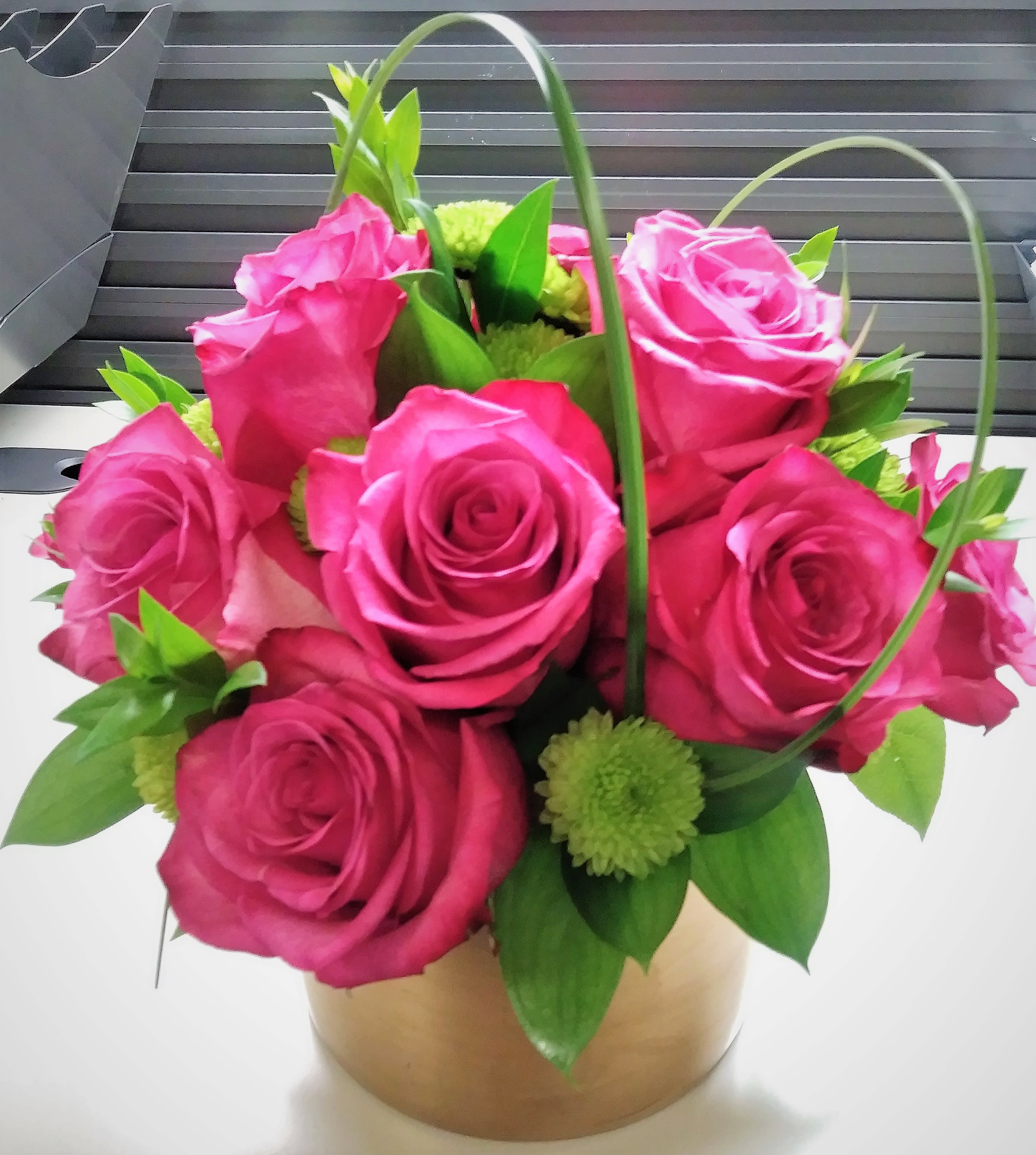 Pink rose bouquet in a gold box with green accents