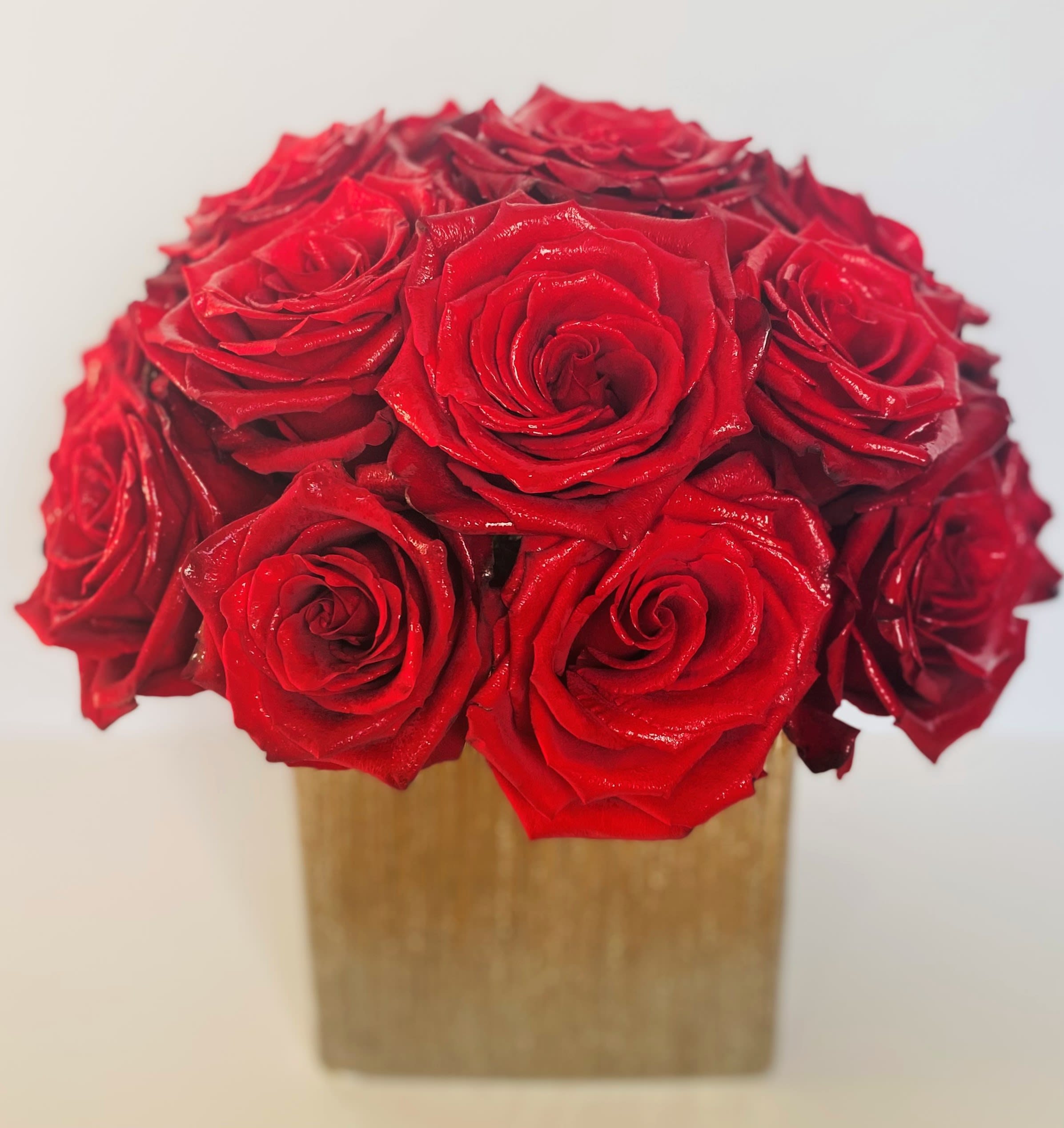 Bouquet of red roses in a square gold box