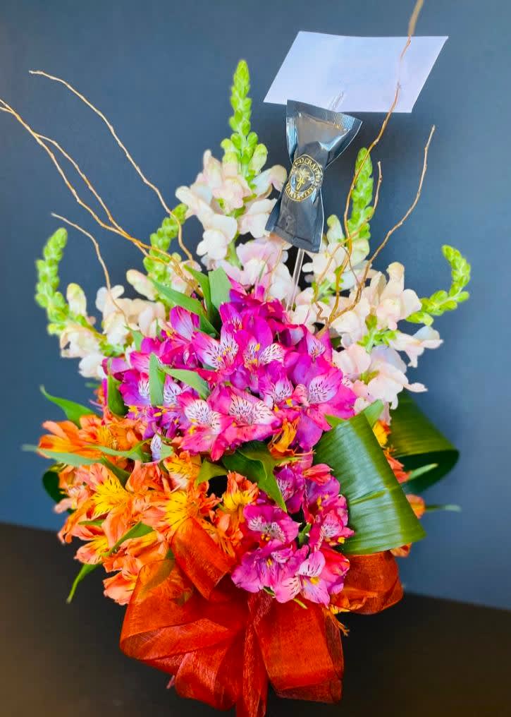 Bright mixed bouquet with pink, orange, and white flowers and a ribbon wrap