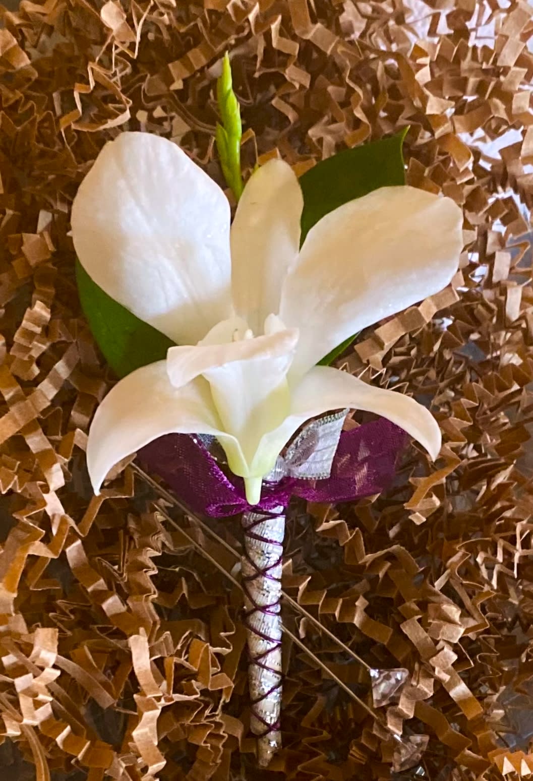 White calla lily boutonniere with purple ribbon wrap