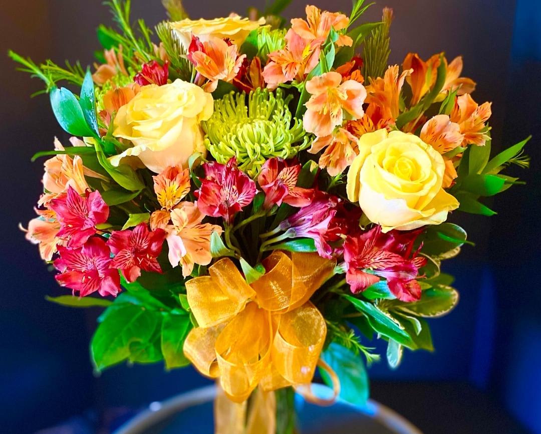 Bouquet of yellow roses and pink alstroemeria with a gold ribbon