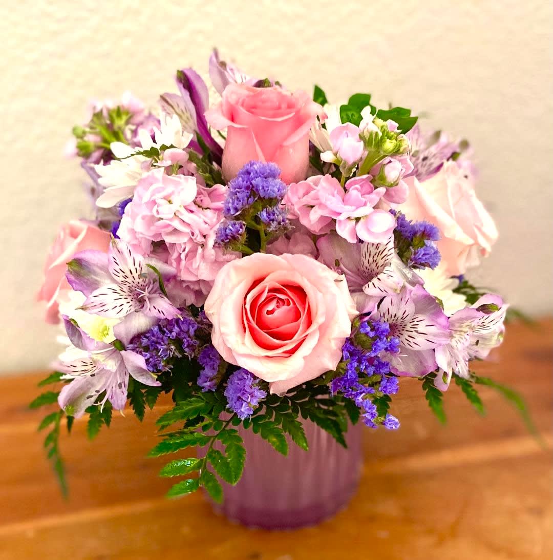 Pink and purple mixed flower arrangement in a lavender vase