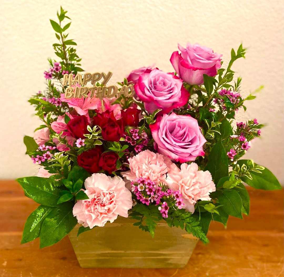 Pink and red rose bouquet with carnations in a vase and a Happy Birthday topper