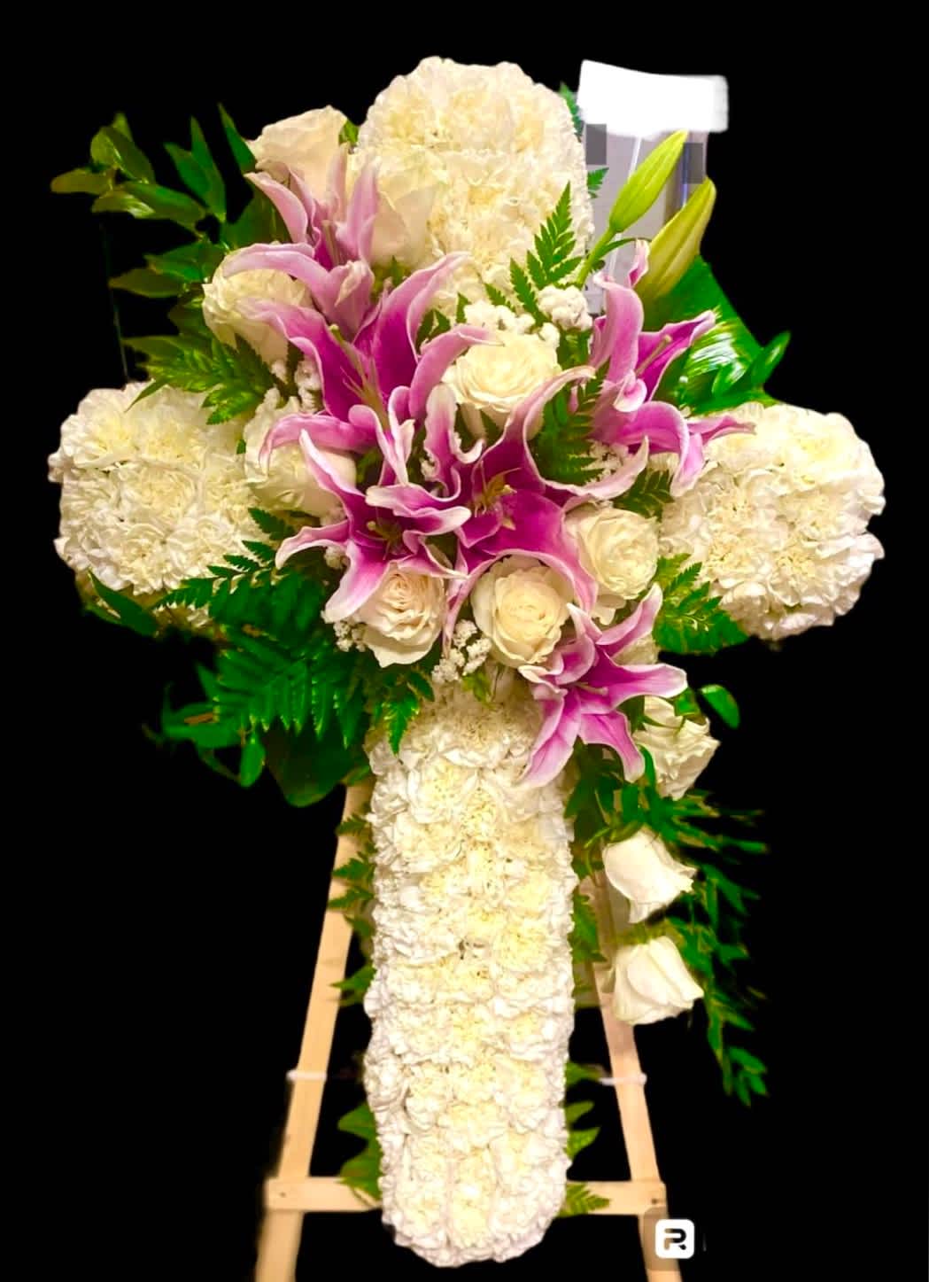 White and pink funeral spray on a wooden easel