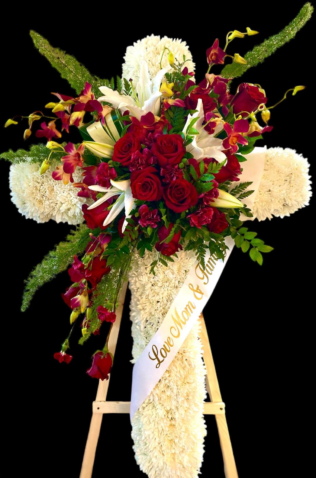 Standing floral spray with red roses, white lilies, and orchids on an easel