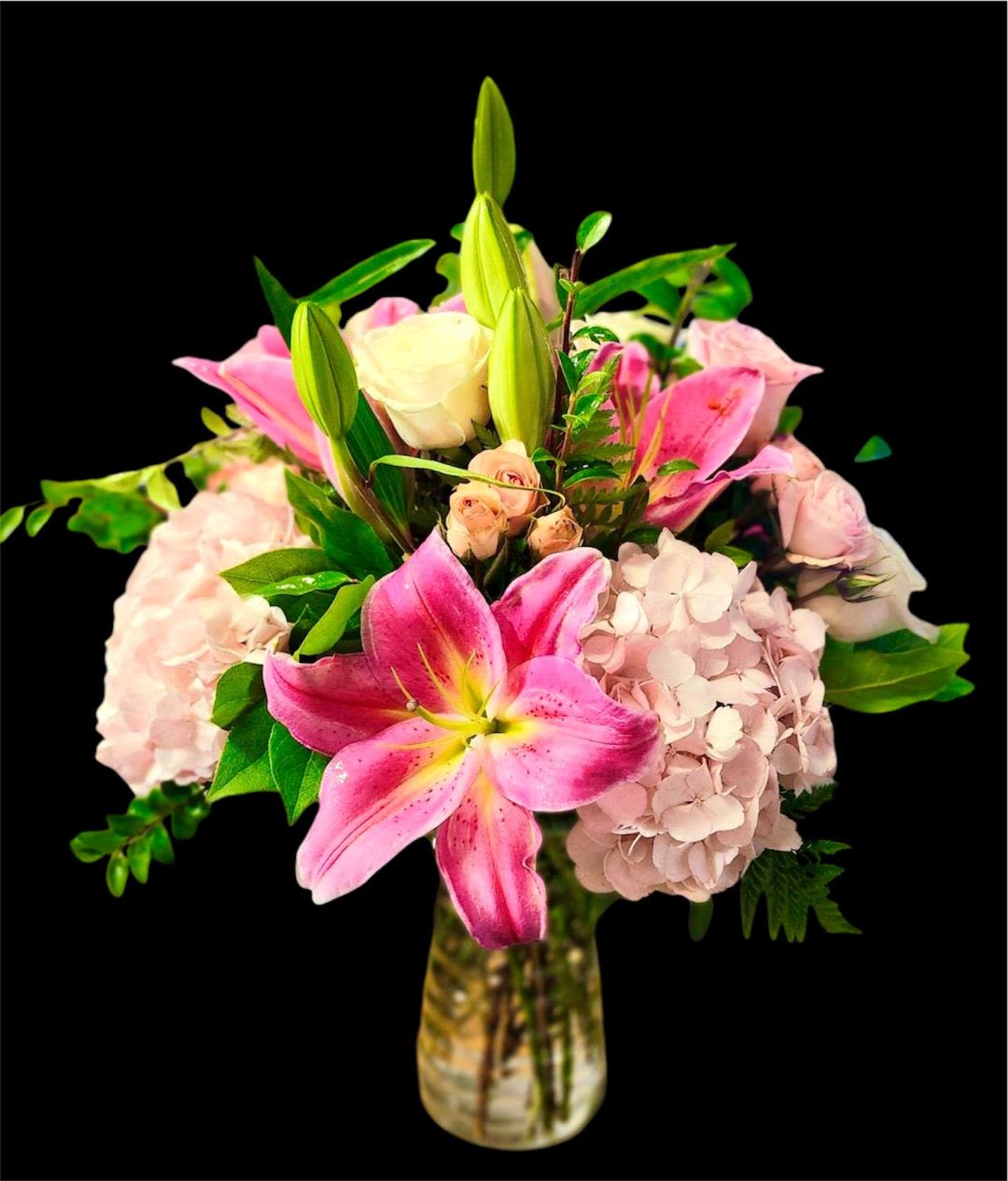 Pink lilies and hydrangeas in a glass vase