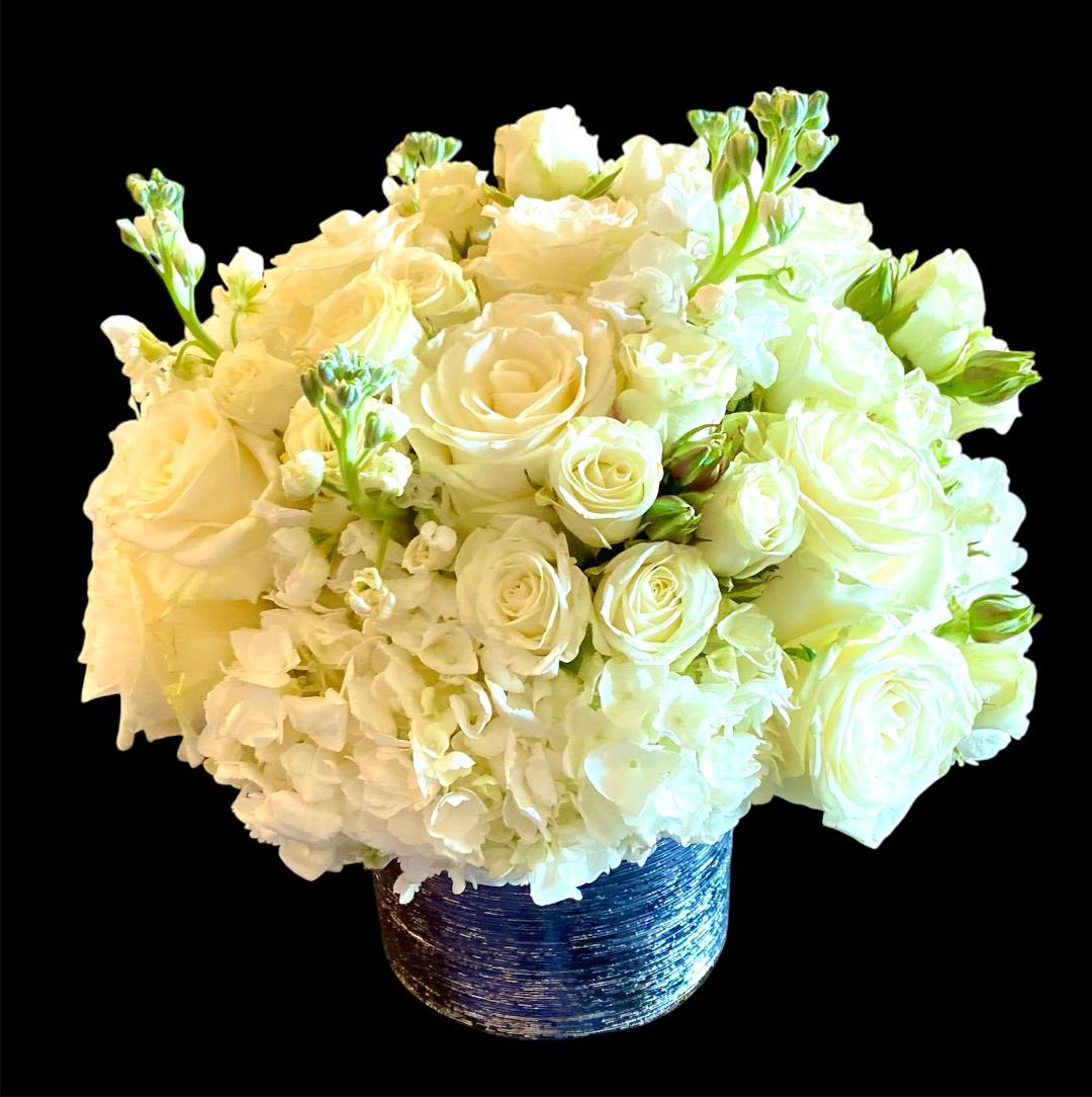 White rose and hydrangea arrangement in a blue textured vase