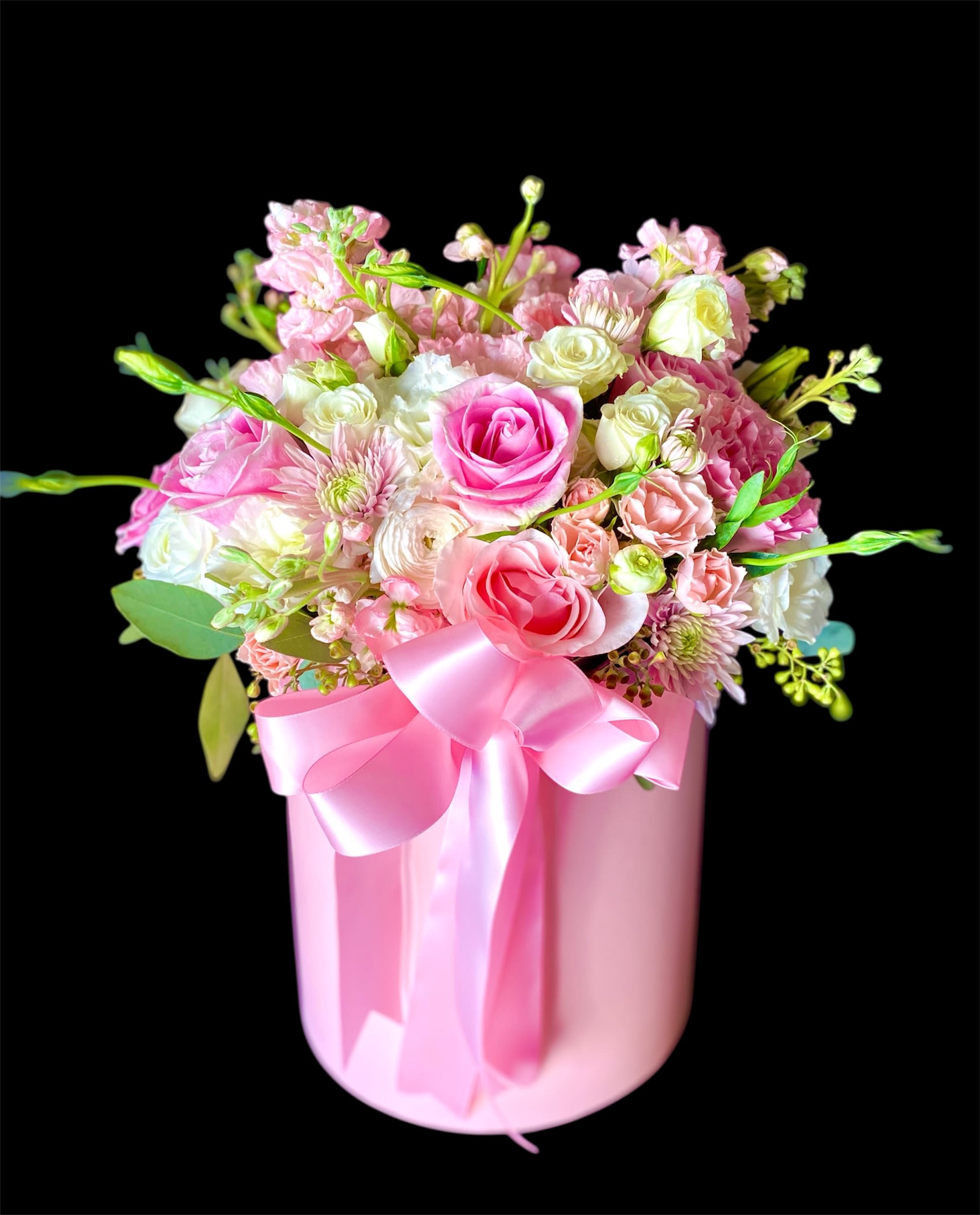 Pink and white mixed flower arrangement in a pink box with a ribbon