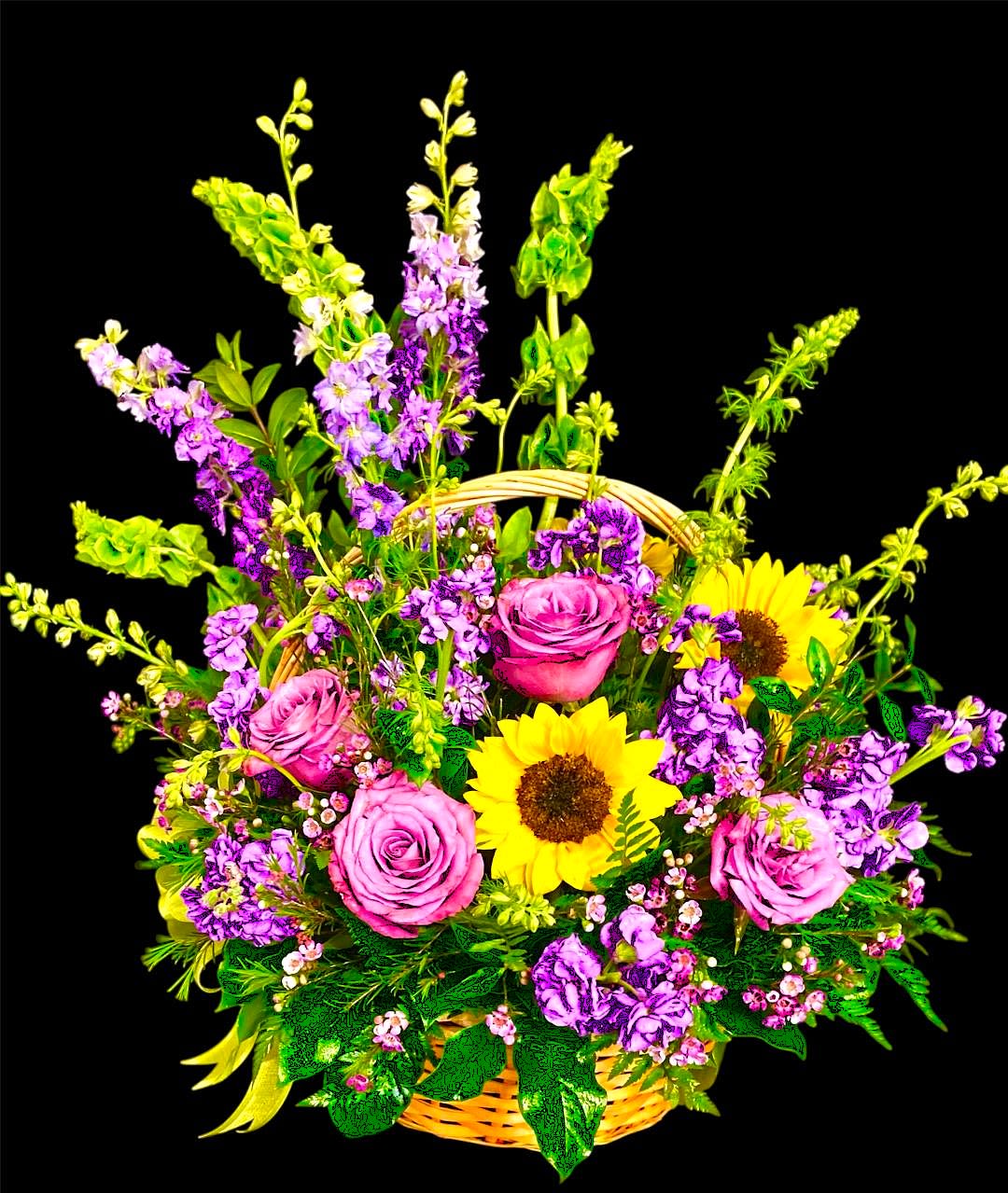 Basket arrangement with pink roses, sunflowers, and purple flowers