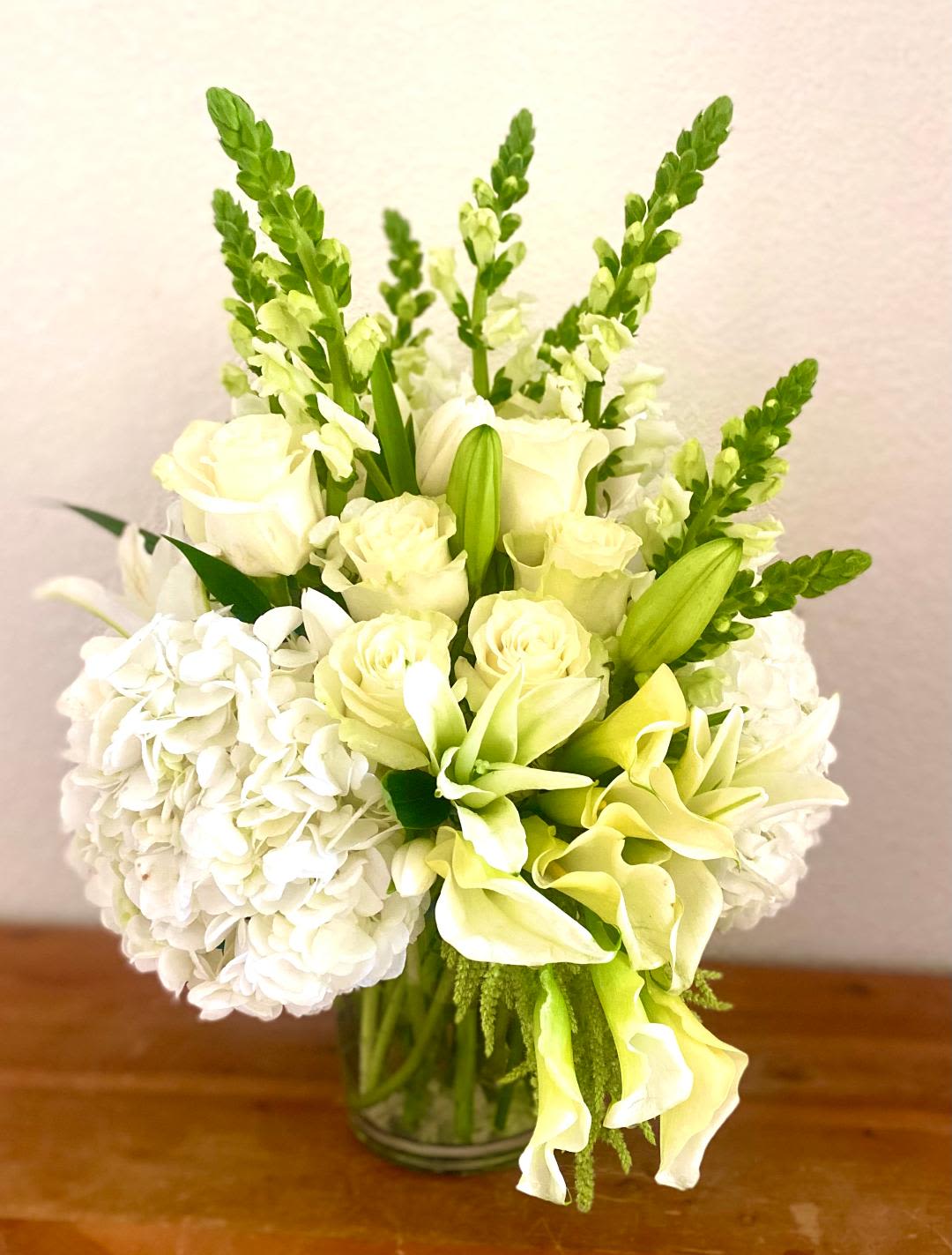 White and pale green floral arrangement in a glass vase
