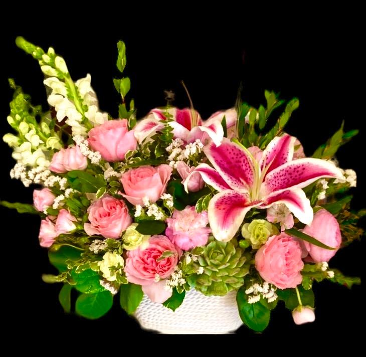 Pink roses and lilies arranged in a white basket