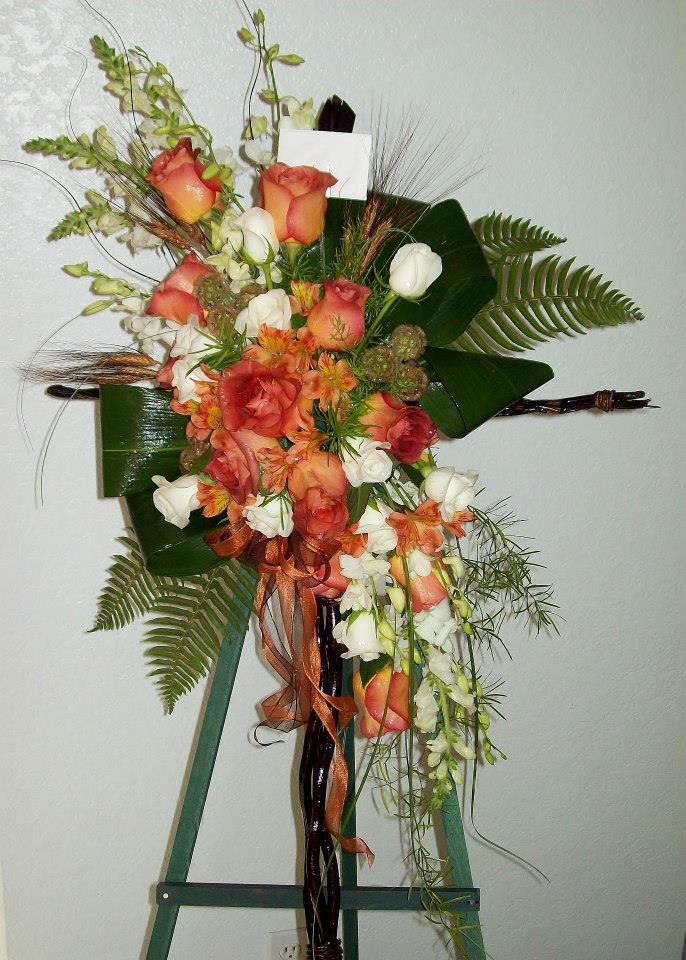 Tall floral spray with peach roses and white blooms on a stand