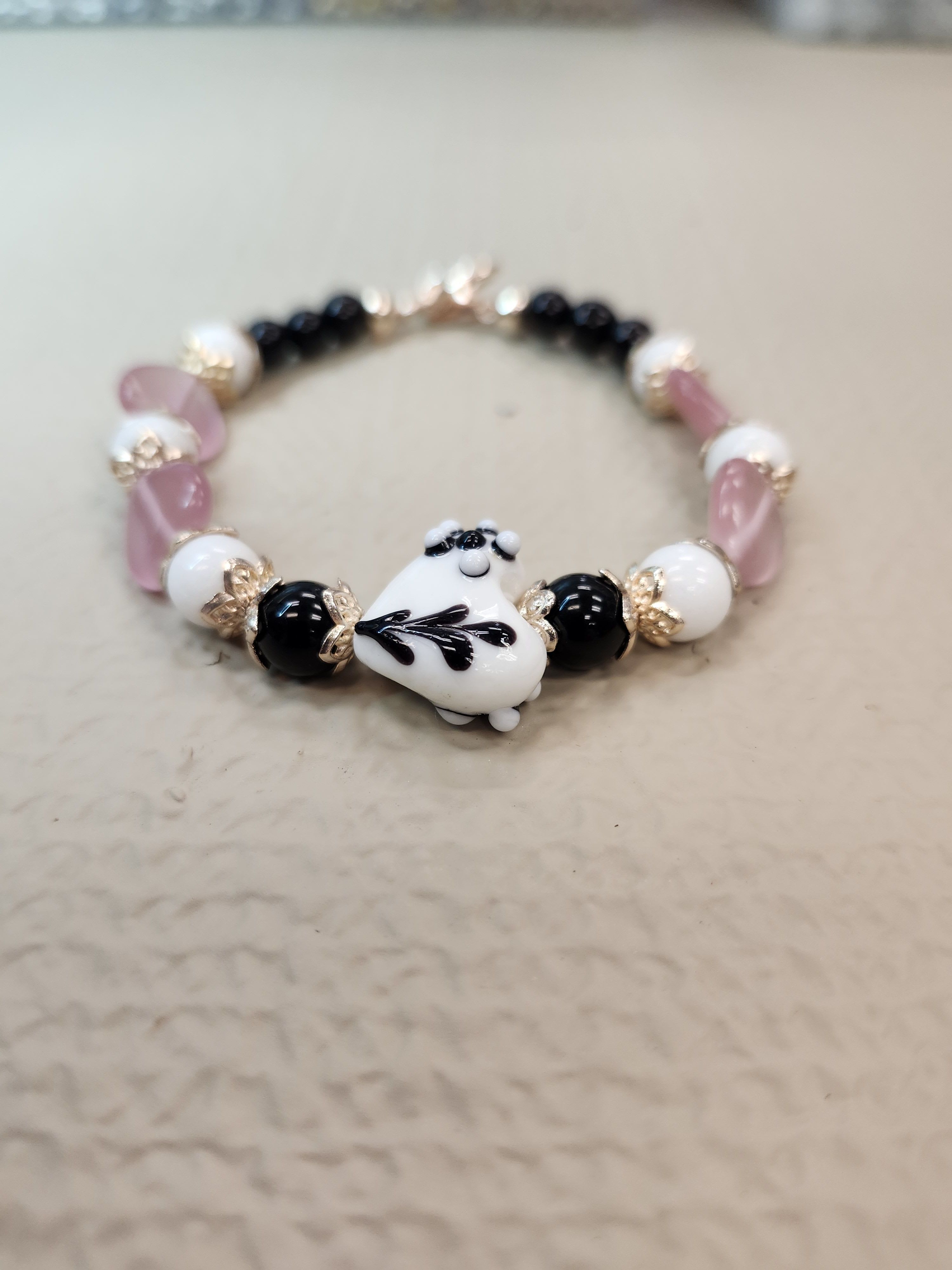 Black and White Lampwork Heart - With Rose Gold accents this beautiful Petite Black and White Lampwork Heart is supported by transparent pink glass hearts and black and white glass beads.  Lobster Claw Clasp.