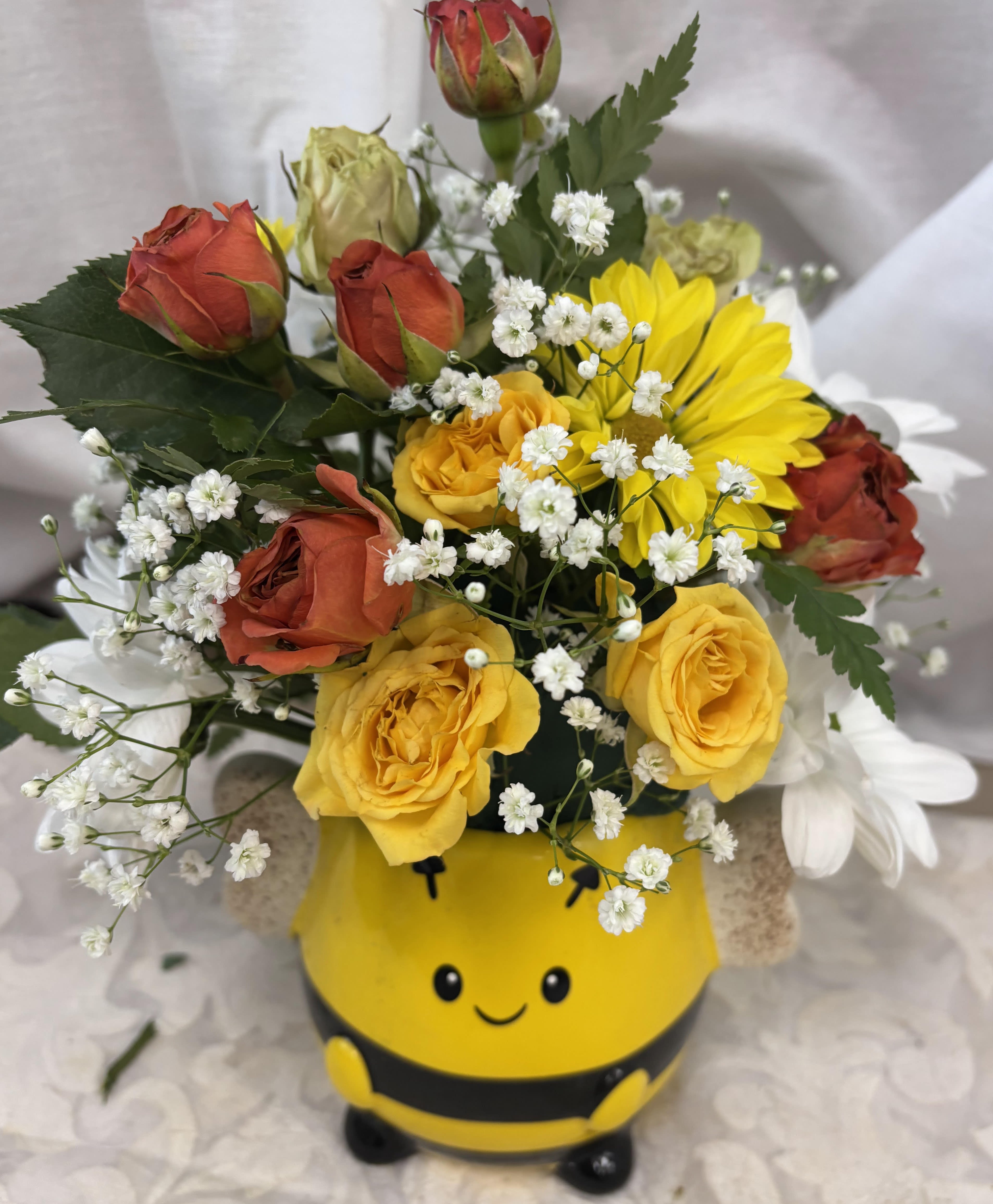 Bee Good - A whimisical Bee vase brightens the day with pretty yellow &amp; other various color spray roses, yellow daisys, babys breath nestled in a bed of seasonal greenery.