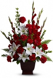 Red and white floral arrangement in a dark vase