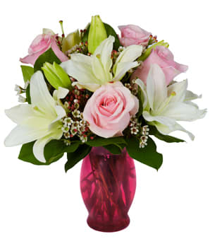 Pink roses and white lilies in a pink glass vase