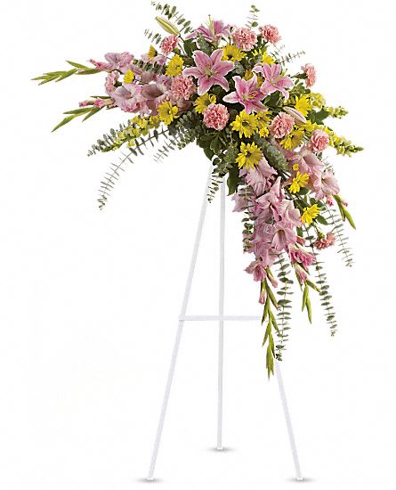 Pink and yellow floral spray on a white easel stand