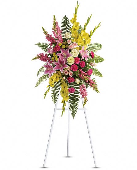 Tall standing floral spray with pink, yellow, and white flowers on a metal easel