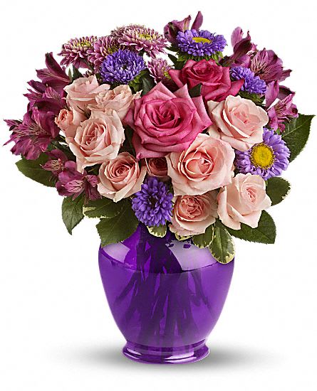 Pink and purple mixed bouquet in a purple glass vase