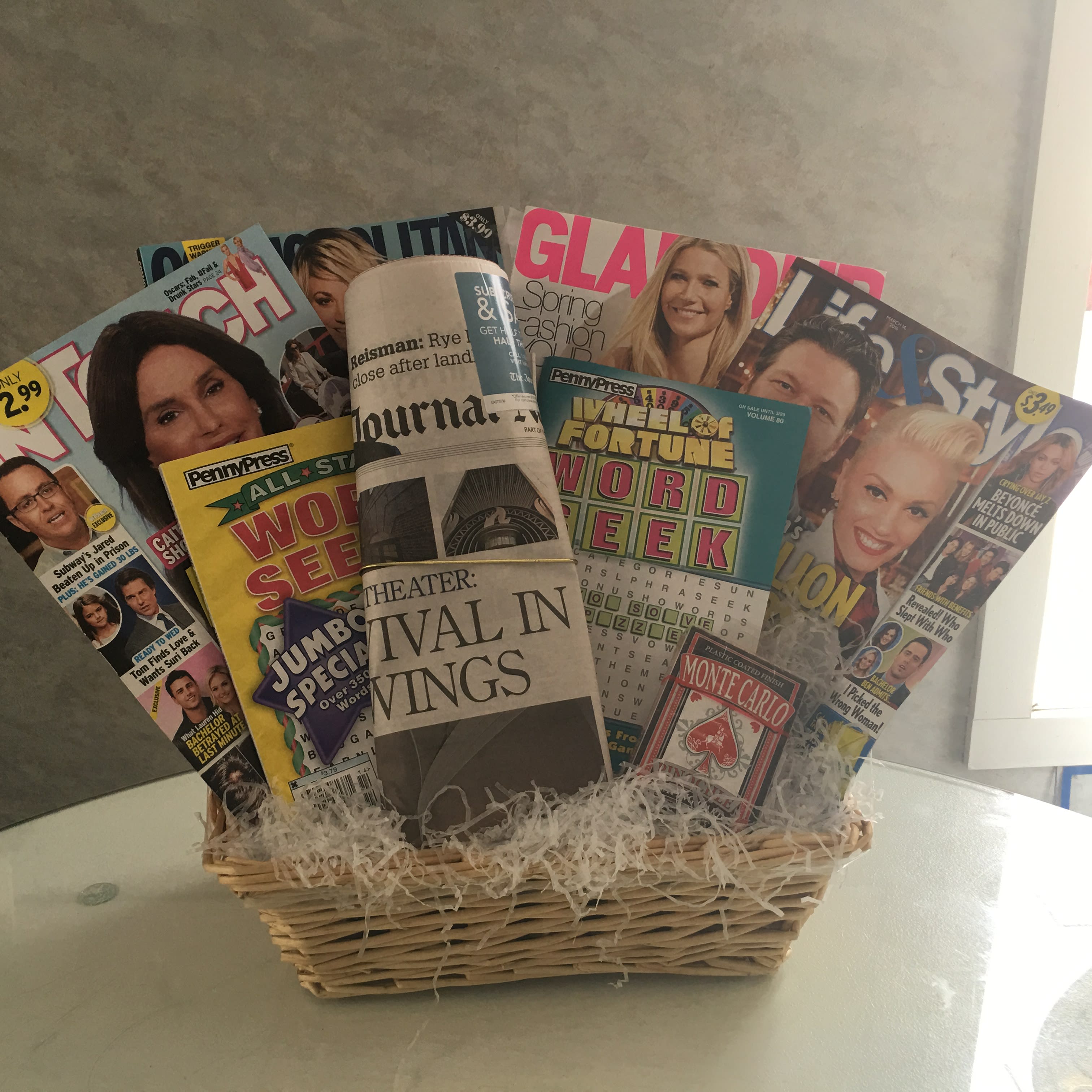 Basket filled with magazines and a rolled newspaper