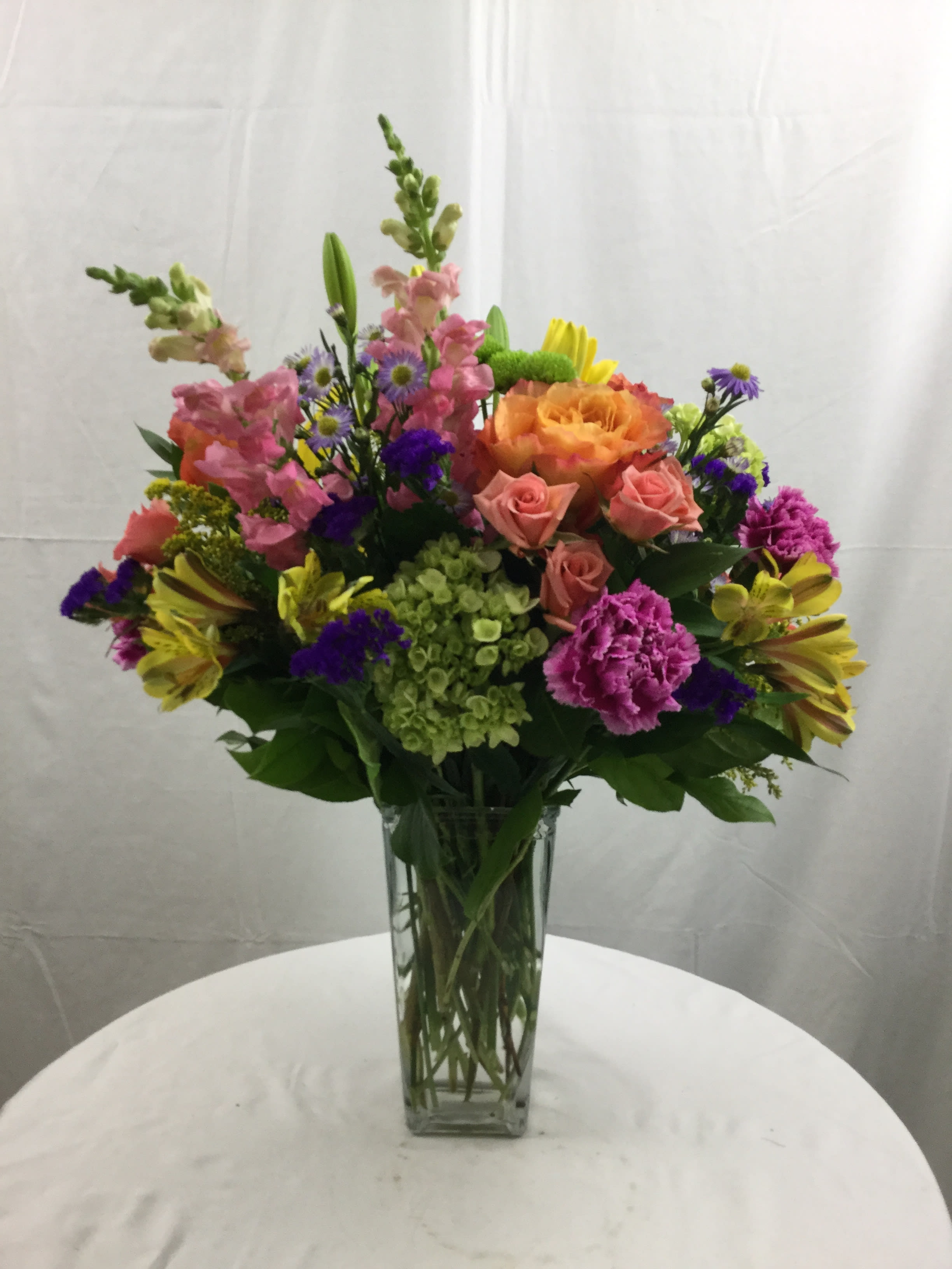 Spring Obsessions - This incredible bouquet is full of love, laughter and the joy of Spring. Hand-crafted and designed in a beautiful tall vase, it makes for a wonderful gift during the Spring and Summer bouquet.